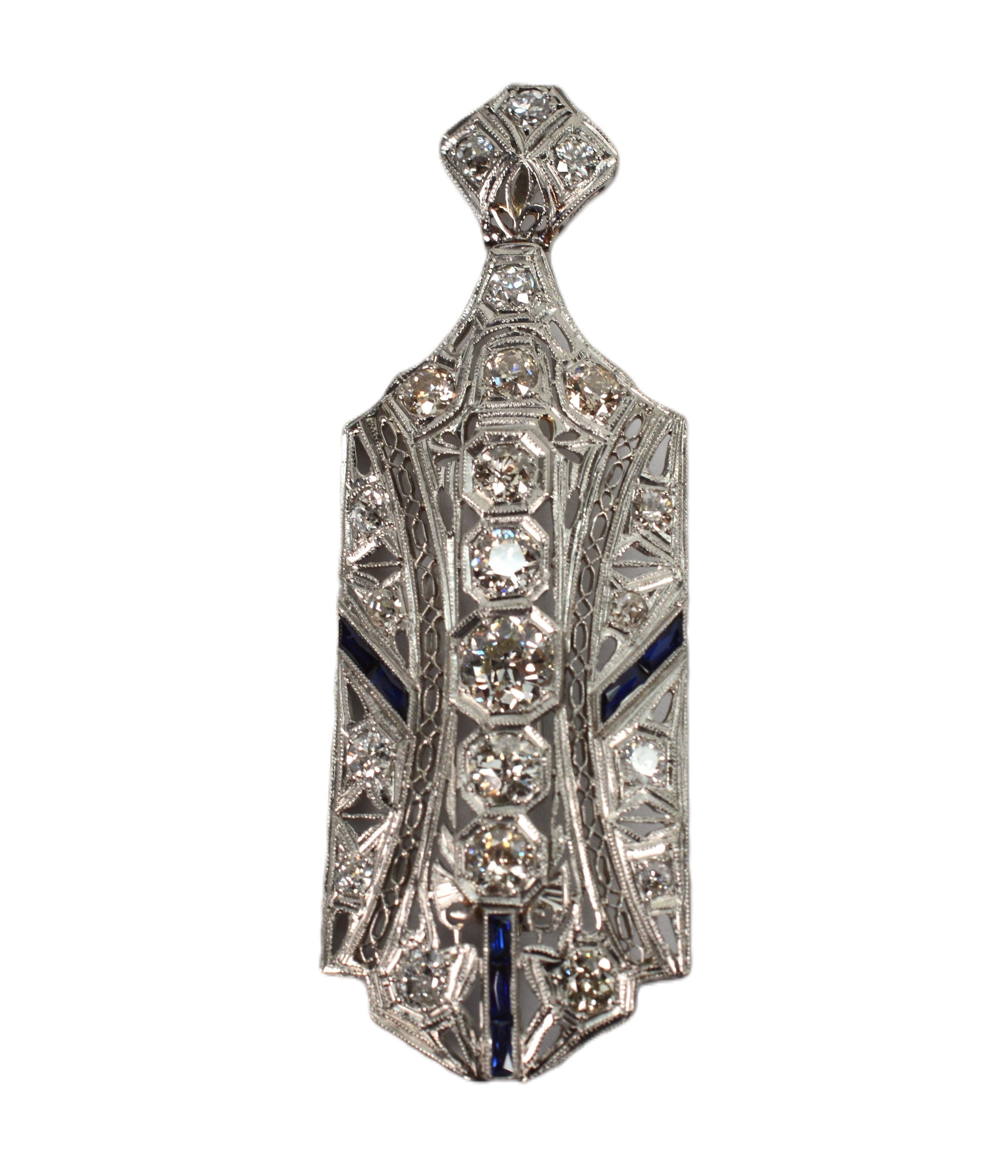 One must appreciate the antique intricacies of the Art Deco design and artful filigree that graces this stunning early century jeweled Brooch Pendant. Skillfully hand-tooled in precious metal, the skilled metal work showcases over 1.5 carats of