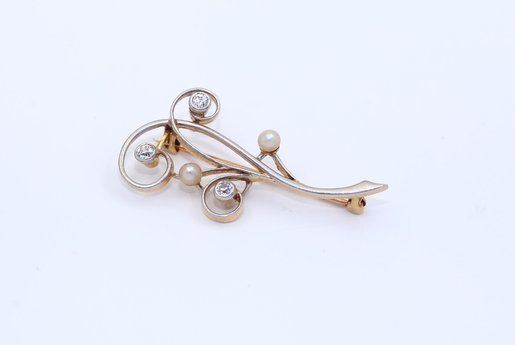 Platinum Gold Old-Mine Diamonds Pearl Brooch. Created around 1930.
Platinum and Gold Old-mine cut Diamond and Pearl swirling brooch. Delicate and elegant brooch depicting a natural branch. There round cut Diamonds and two natural white Pearls.