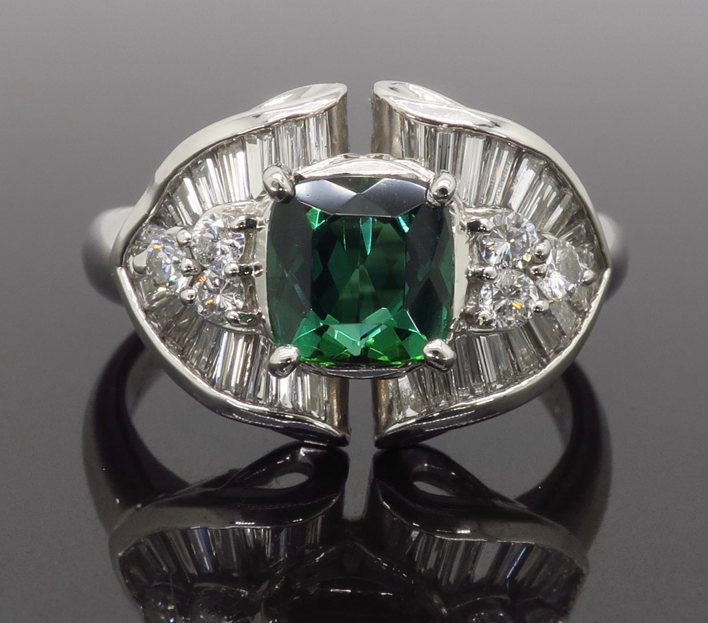 Unique green tourmaline and diamond cocktail ring crafted in platinum.

Gemstone: Green Tourmaline & Diamonds
Gemstone Carat Weight:  Approximately 1.006CT
Diamond Carat Weight:  Approximately .75CTW
Diamond Cut: Round Brilliant Cut and Tapered