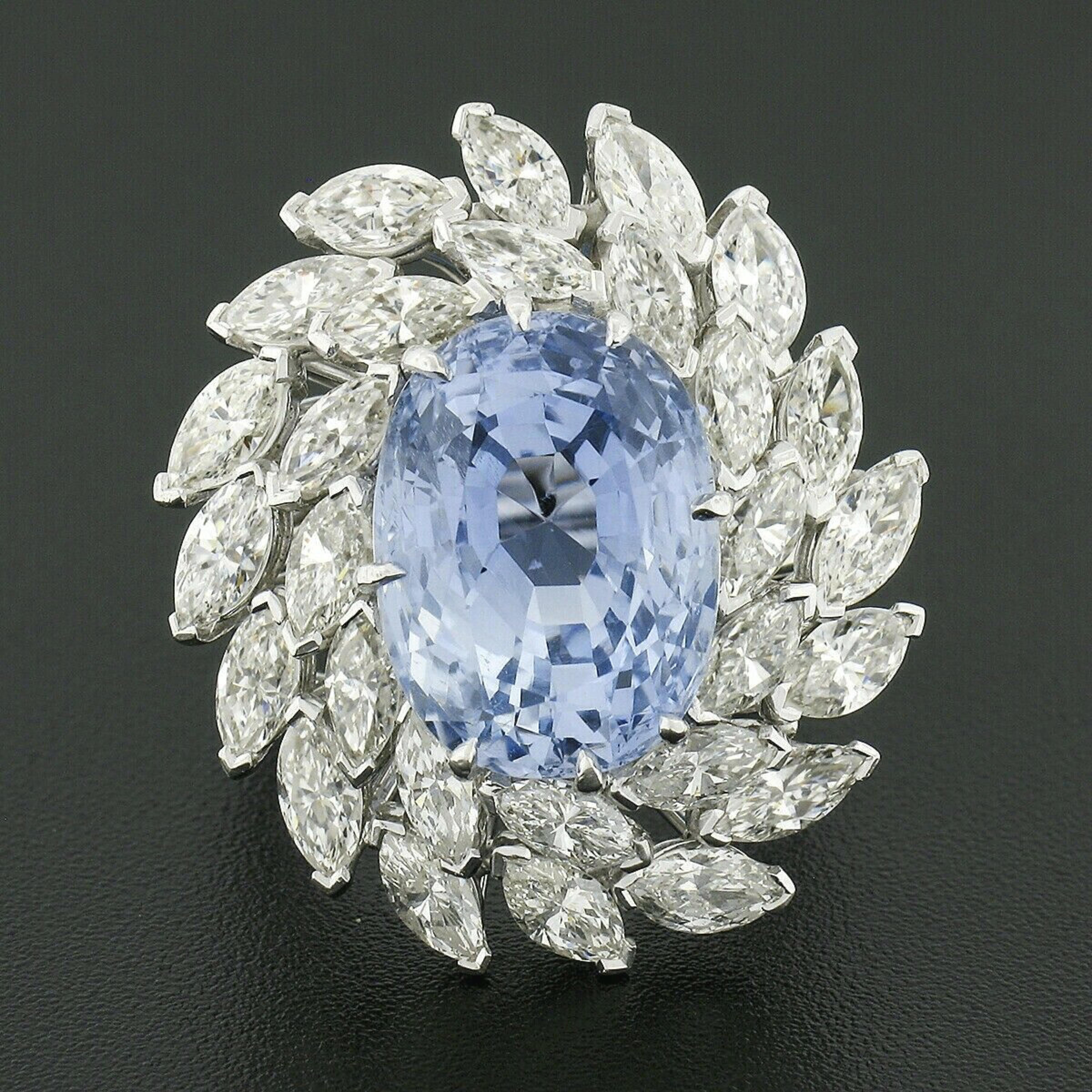 This jaw dropping handmade wire cocktail statement ring is crafted in solid platinum and features a gorgeous, GIA certified, oval brilliant cut sapphire set at the center of a magnificent diamond dual halo. The large sapphire weighs exactly 12.90