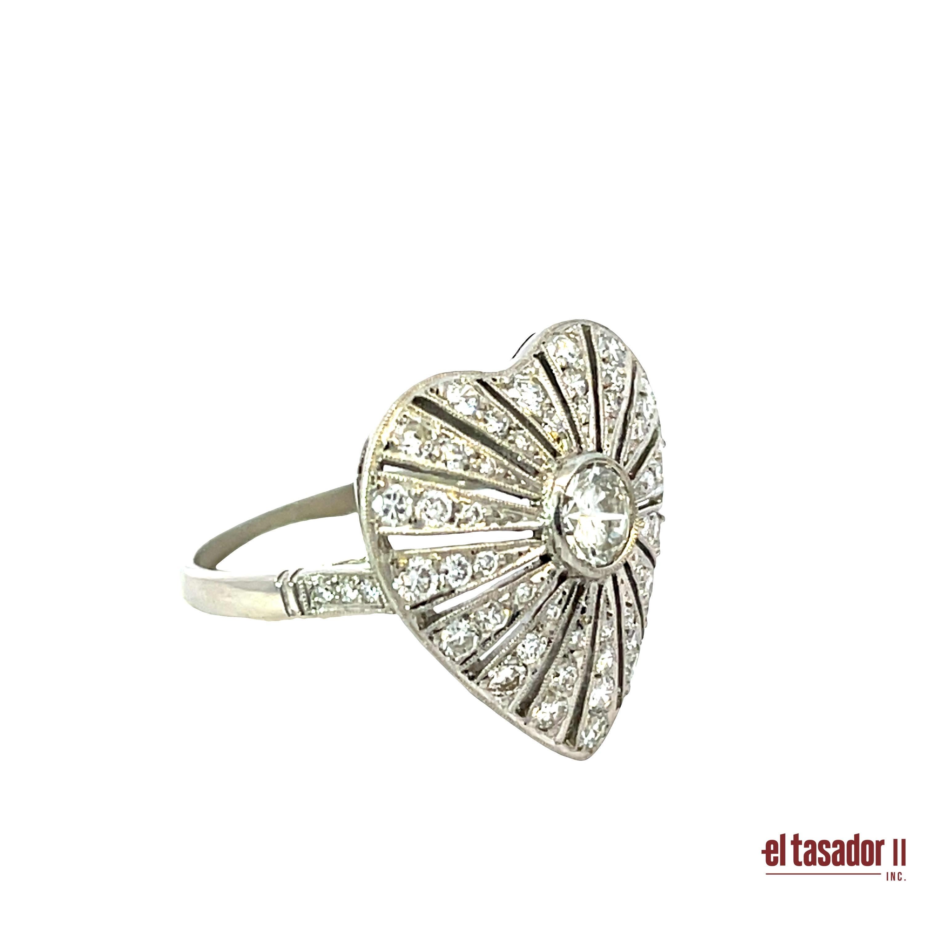 This romantic platinum ring features a heart-shaped silhouette radiating elegance and charm. At its center, a 0.43-carat brilliant-cut diamond is bezel-set, surrounded by 0.69 carats of pavé-set diamonds that form delicate sunburst patterns across