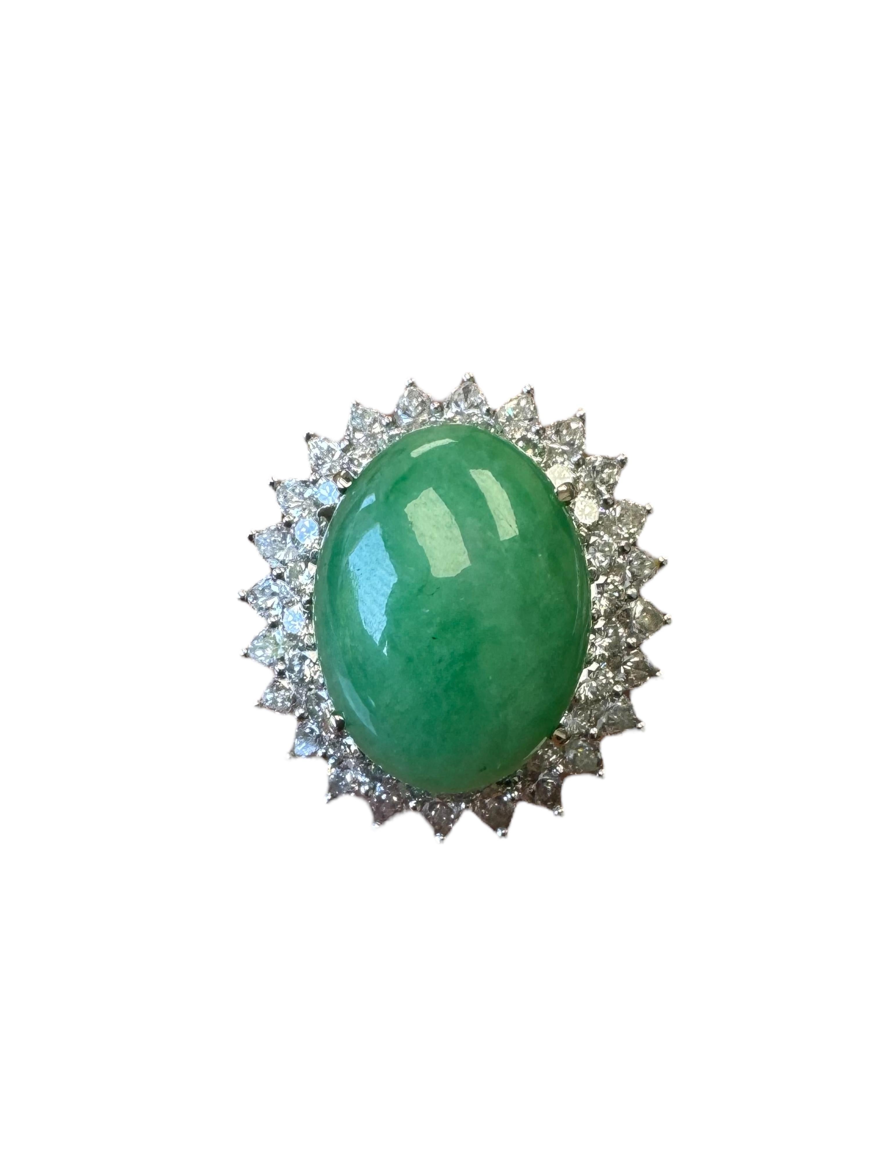 Uno splendido anello di stile Mid-Century realizzato in lussuoso platino, che mostra una vibrante giada cabochon ovale al centro di una classica incastonatura est-ovest. La giada è circondata da 24 diamanti taglio marquise per un totale di circa