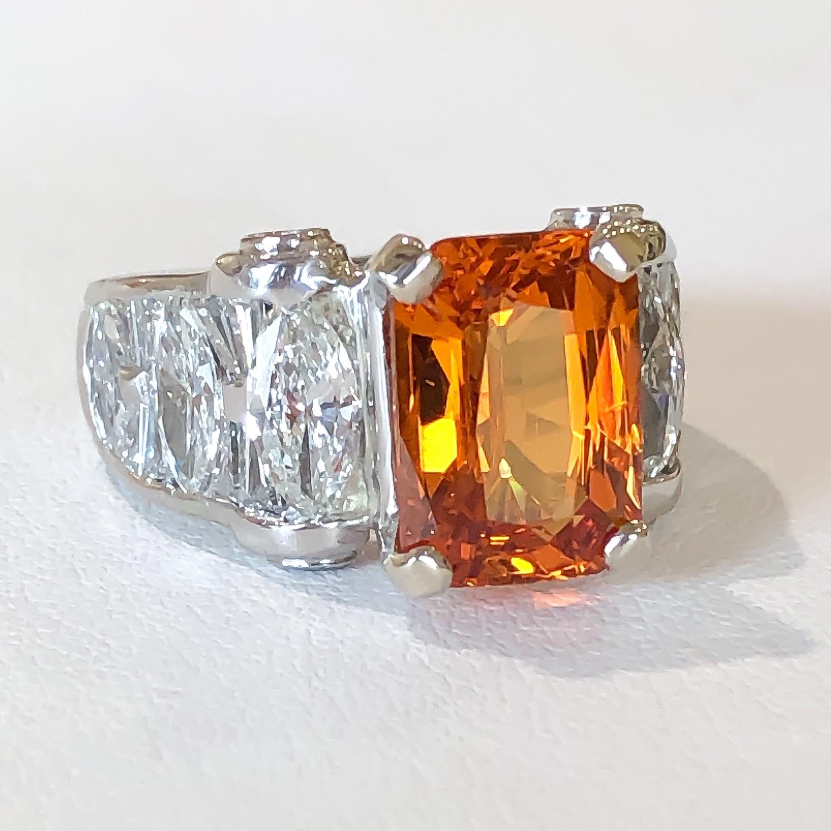 This ring is designed by J.B. STAR in Platinum, set with a vibrant natural mandarin Spessartite Garnet. The Spessartite Garnet is a fancy mixed radiant cut shape set in four heavy prongs. Marquise, tapered baguette, and round brilliant diamonds