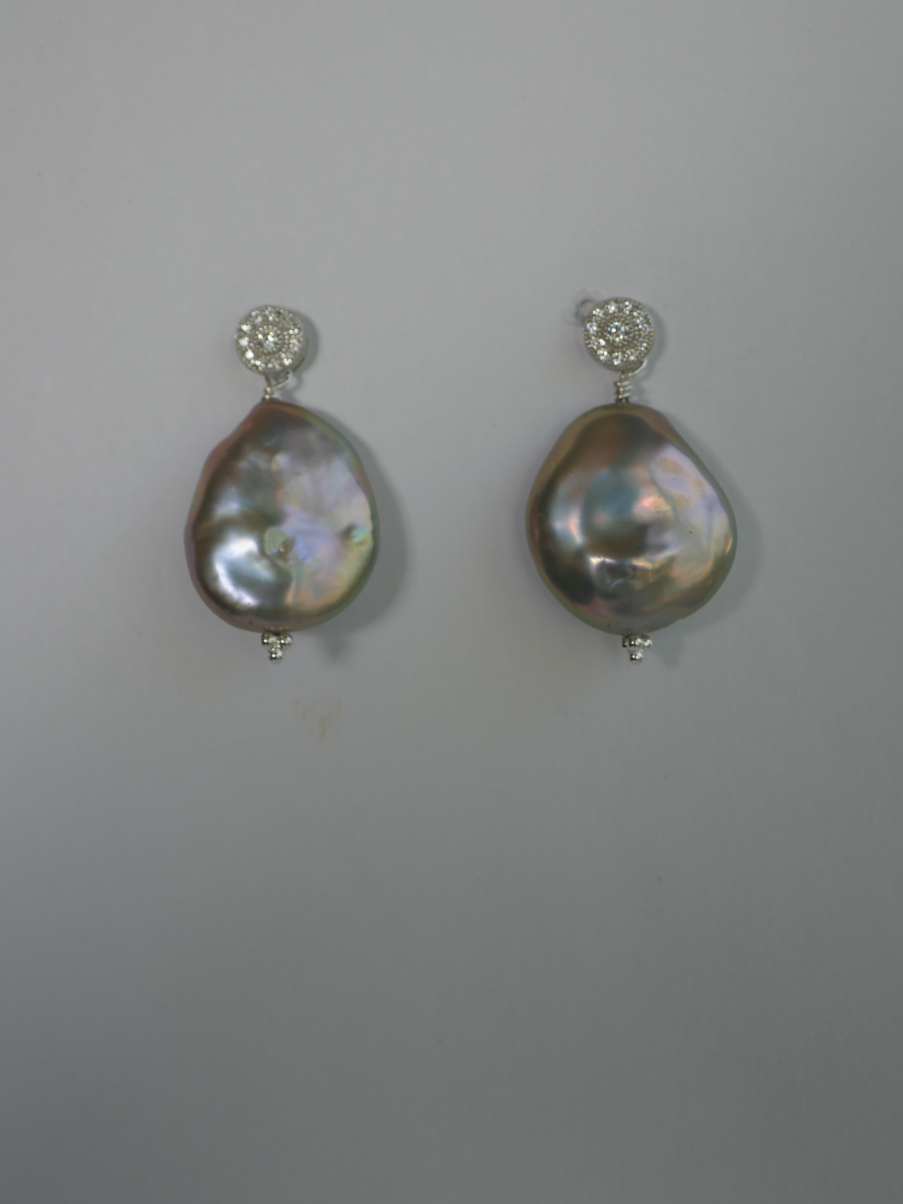 The earrings have two large platinum grey keshi coin cultured pearl on 925 sterling silver cubic zirconia post. The size of the pearls is approximately  22.5mm  x 26mm  The post are screw back but rubber backs may be used. The earrings are 1 3/8 