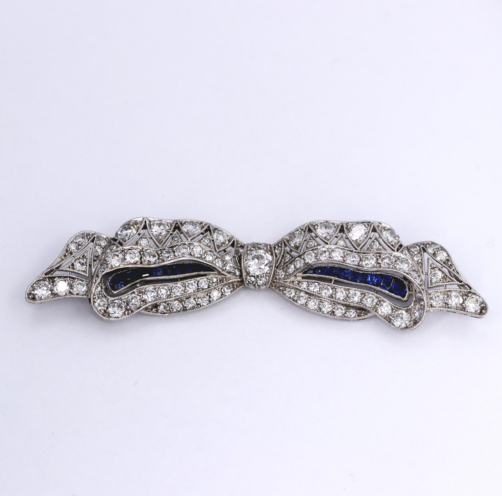 One ladies early twentieth century bow brooch set with assorted old European cut diamonds weighing approximately 4.25ct of overall G-I color and VS1-SI1 clarity. Inside the bow, on either side are channels set with a total of 18 French cut sapphire
