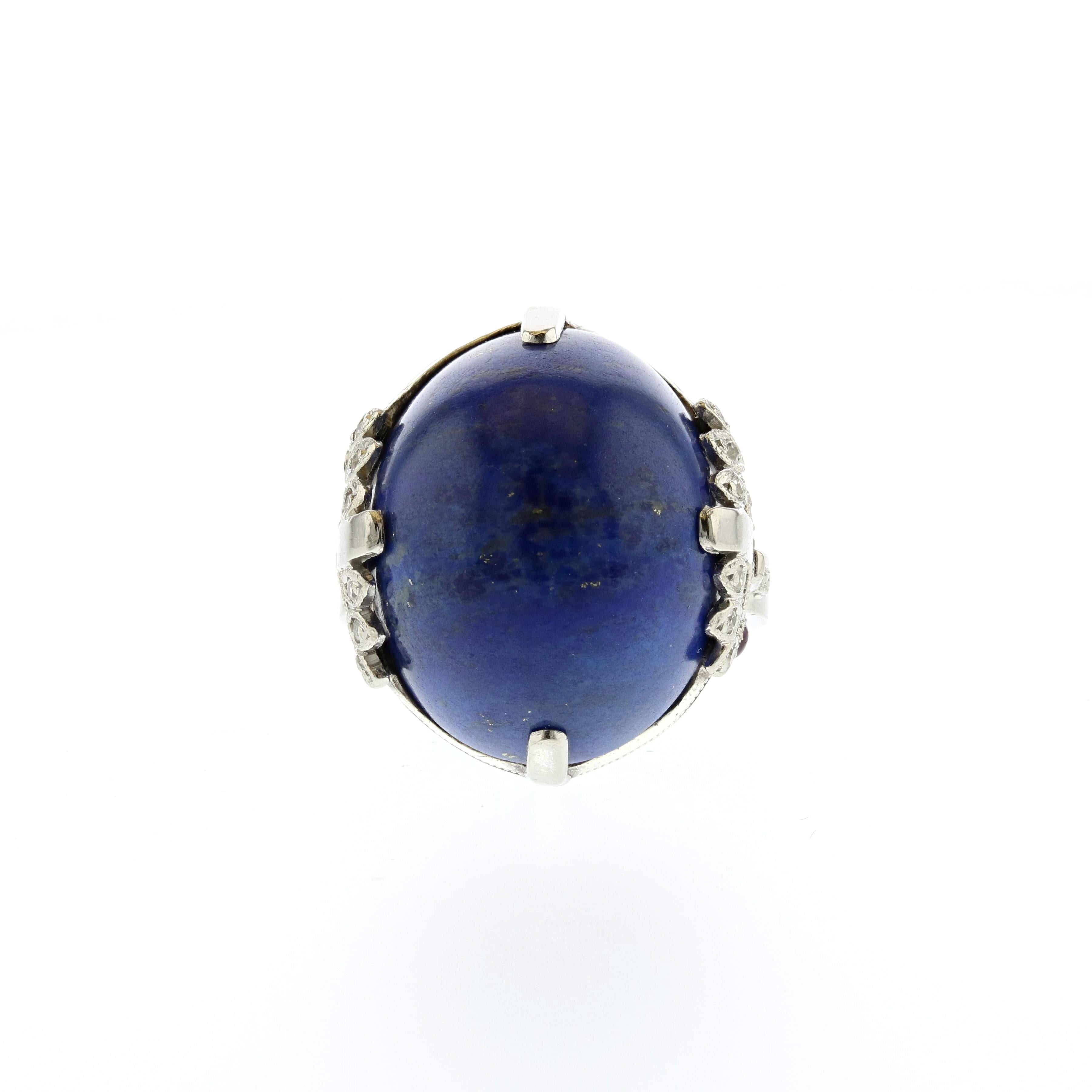 Platinum ring with a cabochon Lapis Lazuli stone.  The mounting has small diamonds as well as rubies.  The Lapis weighs 22.0 carats.  There are eighteen (18) single cut diamonds totaling 0.15 carats; they are I-J in color and SI1-2 in clarity.  The