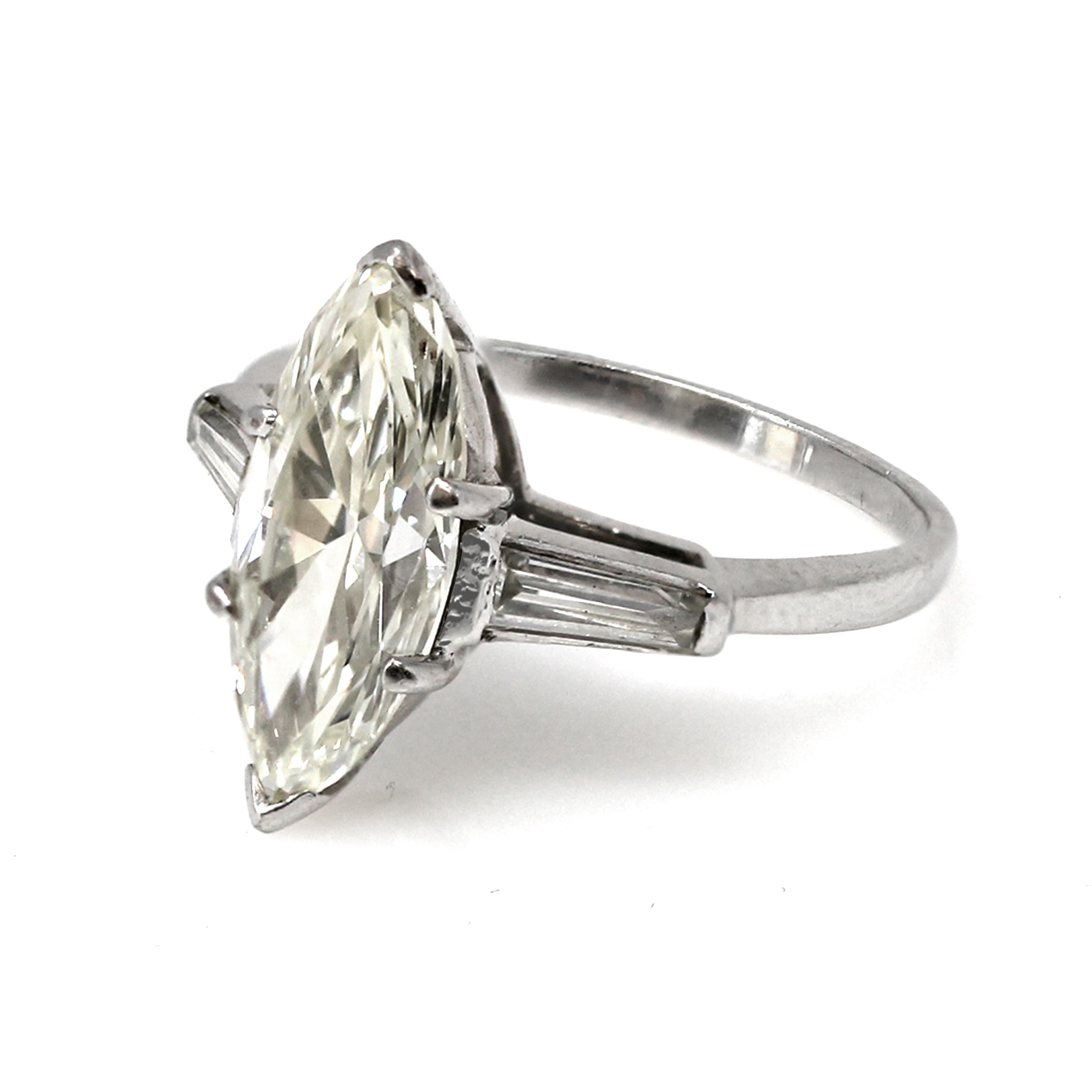Circa 1940s-1950s this superb Old-cut Marquise diamond of 2.96 carats is flanked with 0.20 carat tapered baguette diamond on each side, set on a handmade platinum mounting. The Old-cut Marquise diamond is estimated to be VS in clarity and KL in