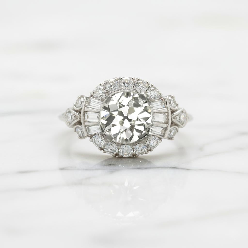 Cette bague de cocktail vintage saisissante, qui capture le glamour d'une époque révolue, présente en son centre un magnifique diamant de taille européenne ancienne de 1,28 carat - un authentique diamant façonné pendant la période Art of Vintage,