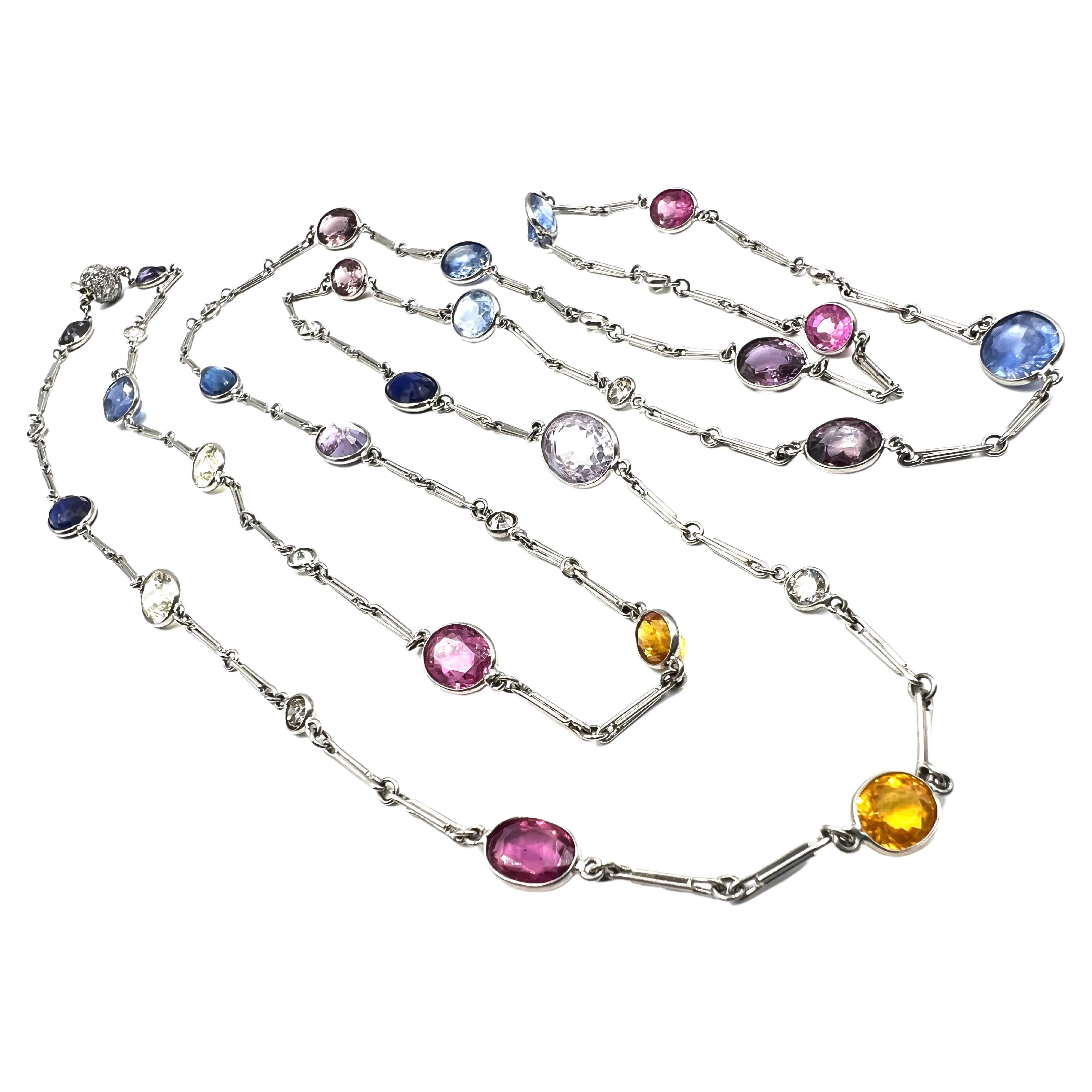 Platinum chain necklace in a gemstone by the yard design, featuring alternating multicolored sapphires and diamonds. Bezel set with 24 oval mixed cut sapphires totaling approximately 37.25 carats (two pale yellow, two yellowish-orange, six