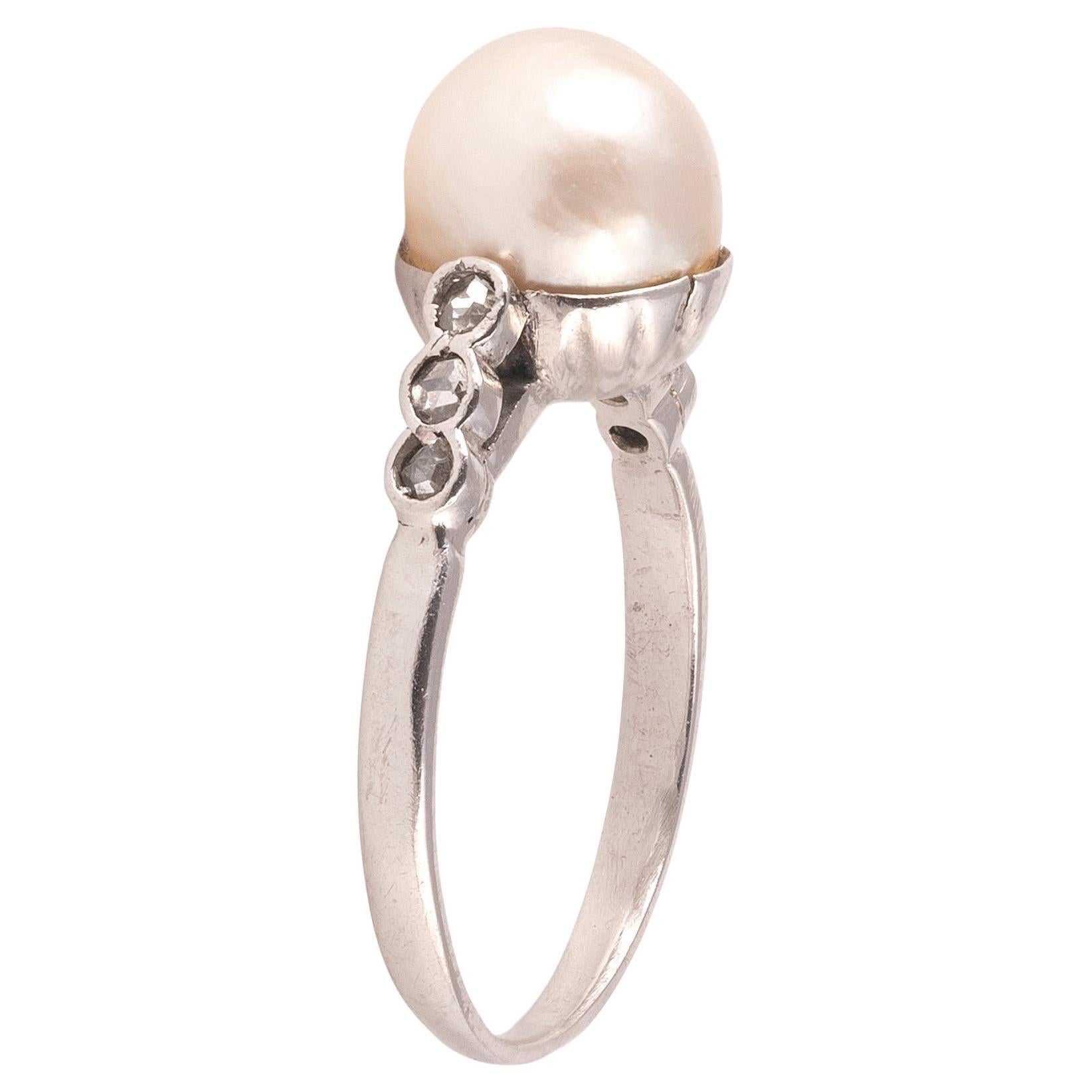 The 8mm natural pearl set to either side with three graduated rose cut diamonds.
Mounted in platinum.
Ring size 5
Weight: 2.9gr.

