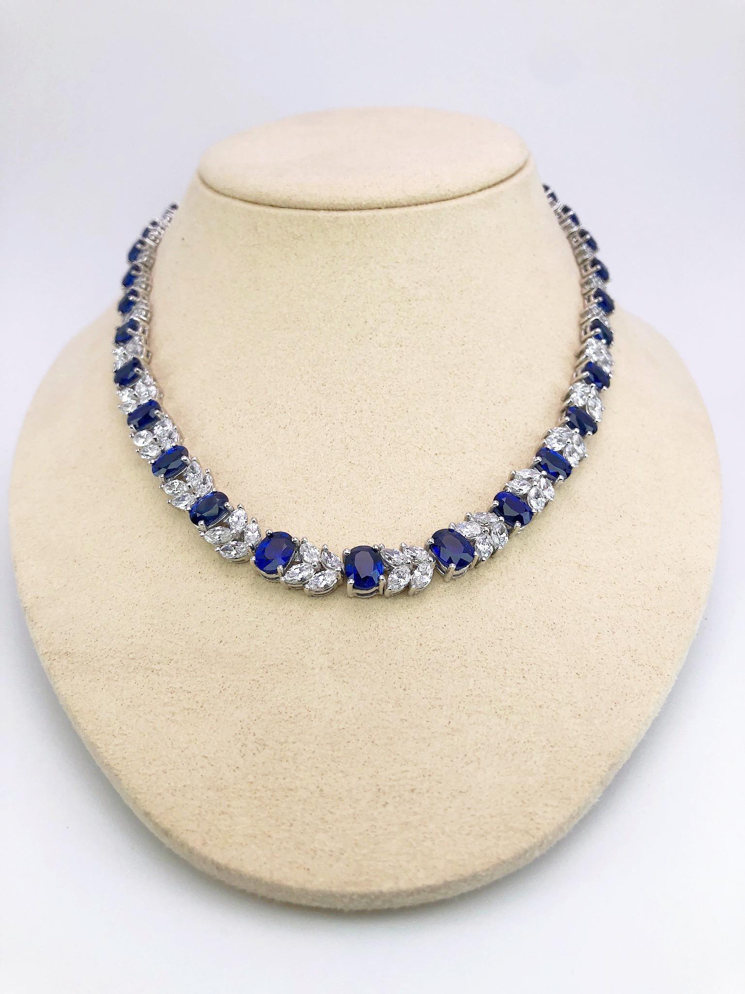 This platinum wreath necklace is designed with 33 oval blue sapphires. The sapphires alternate with a pattern of marquise and round diamonds. Total length 15.5