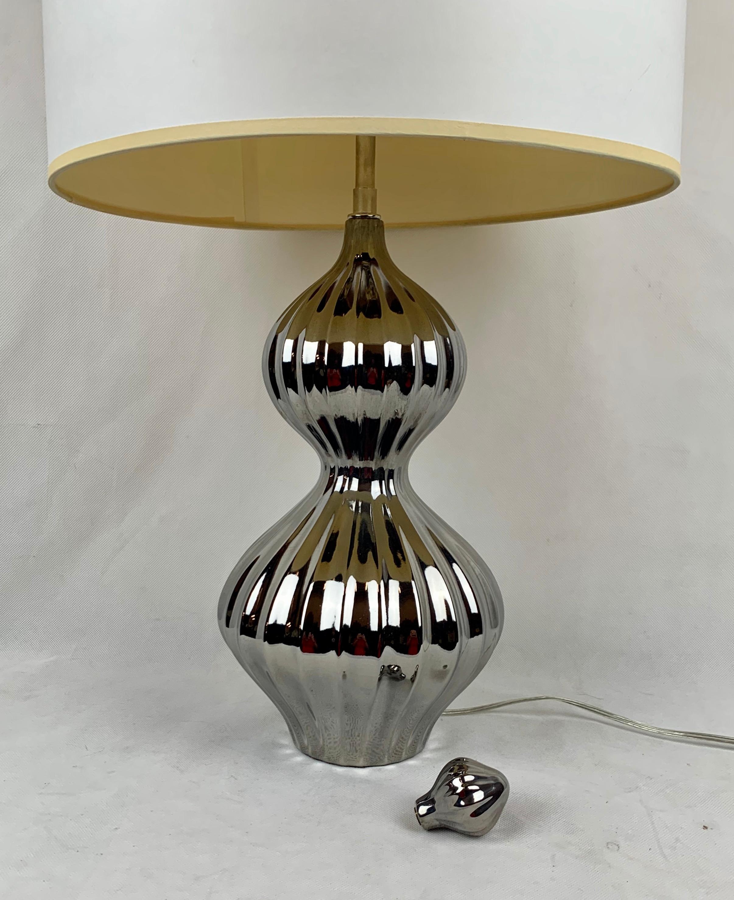 Vintage Jonathan Adler's platinum nelson lamp c. 2010. The lamp is high fired stoneware with a platinum glaze. The double gourd body is ribbed and has a matching platinum glazed finial. The lampshade is white.
Measures: Height to