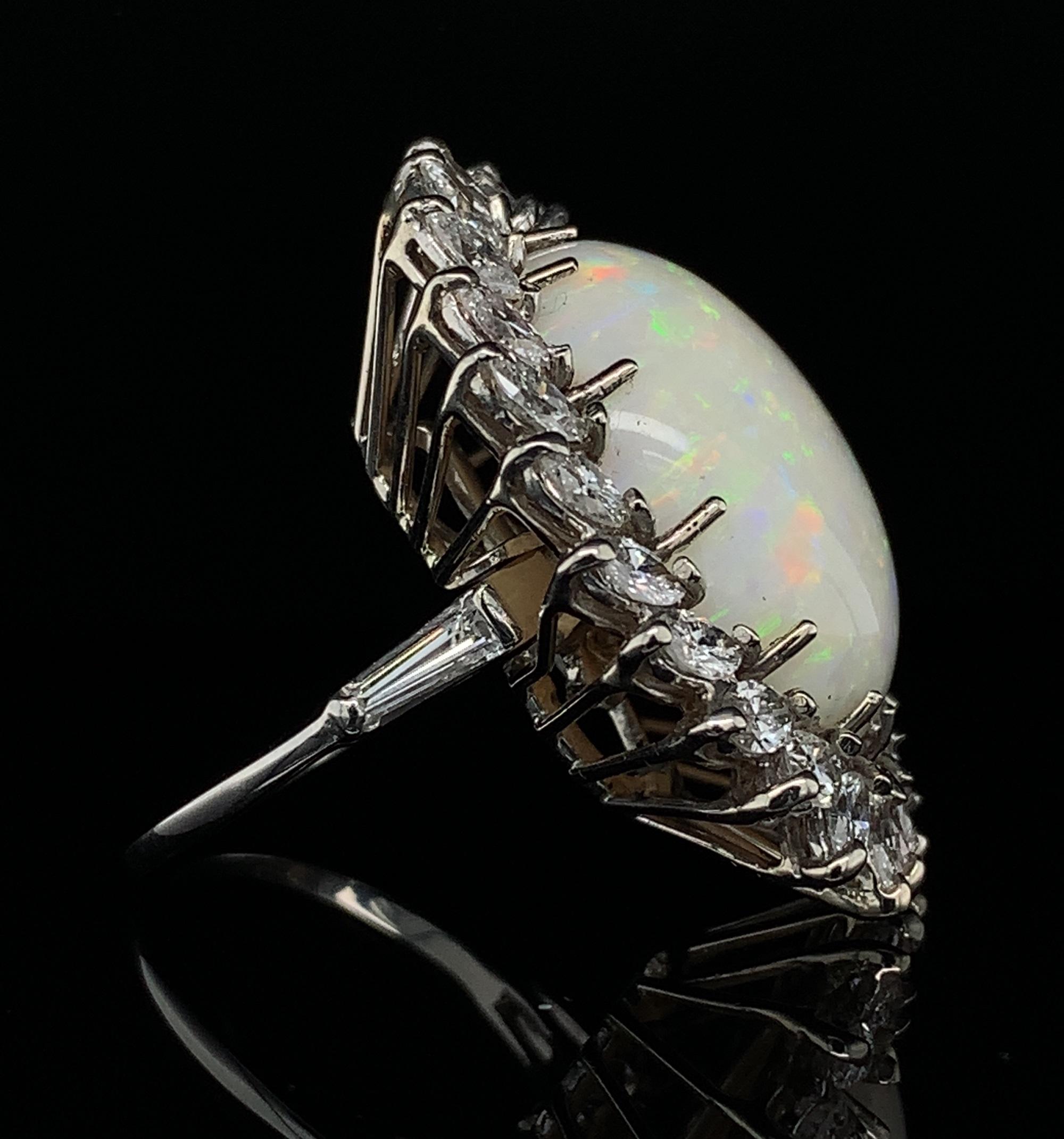 Platinum opal and diamond ring which converts to a pendant. There is a locking mechanism where the shank can be removed and a bail can flip up. The large Australian opal weighs almost 18 carats. It measures about 22mm x 17.5mm. The opal has green,