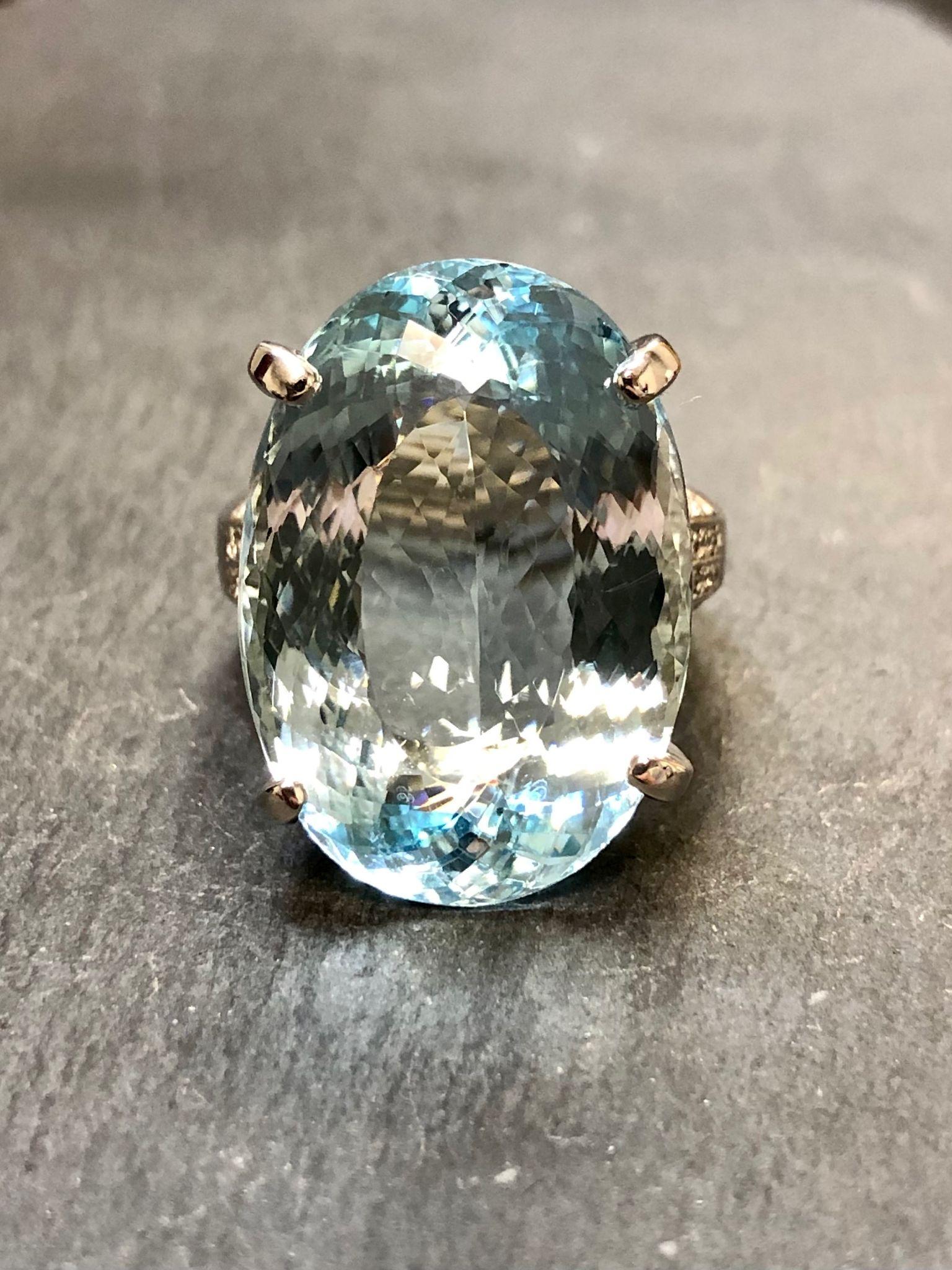 This fabulous ring has been done in platinum and set with .16cttw in H-I Vs2-Si1 clarity diamonds and centered by an oval natural aquamarine weighing 28.42ct. The color is a medium blue tone and exemplary of better aquamarine material used in finer