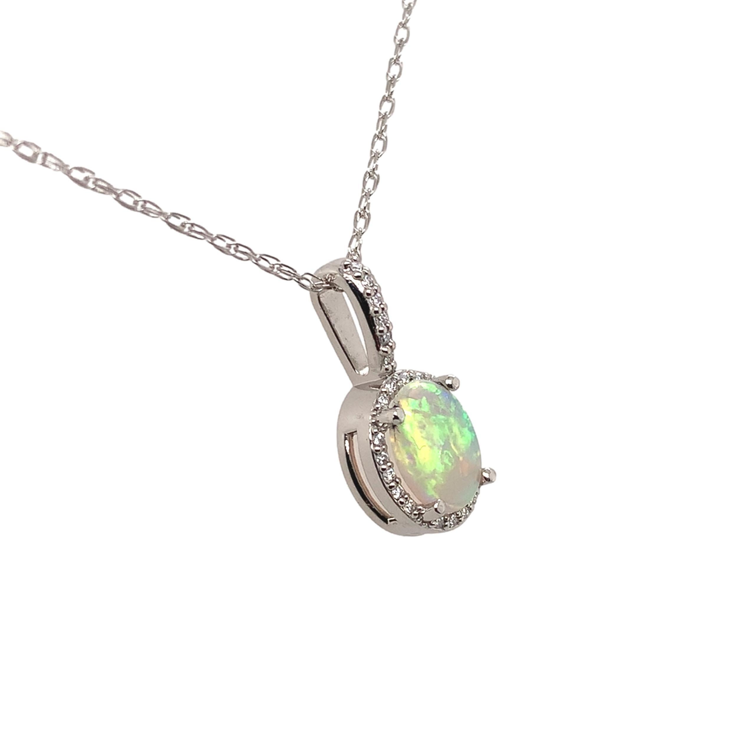 Ciondolo in platino con opale australiano estratto dalla terra e diamante. L'opale ovale tagliato a cabochon misura circa 8 mm x 6 mm e presenta vivaci giochi di colore con tutti i colori, compreso il rosso. L'opale pesa .60cts. Ci sono 24 piccoli