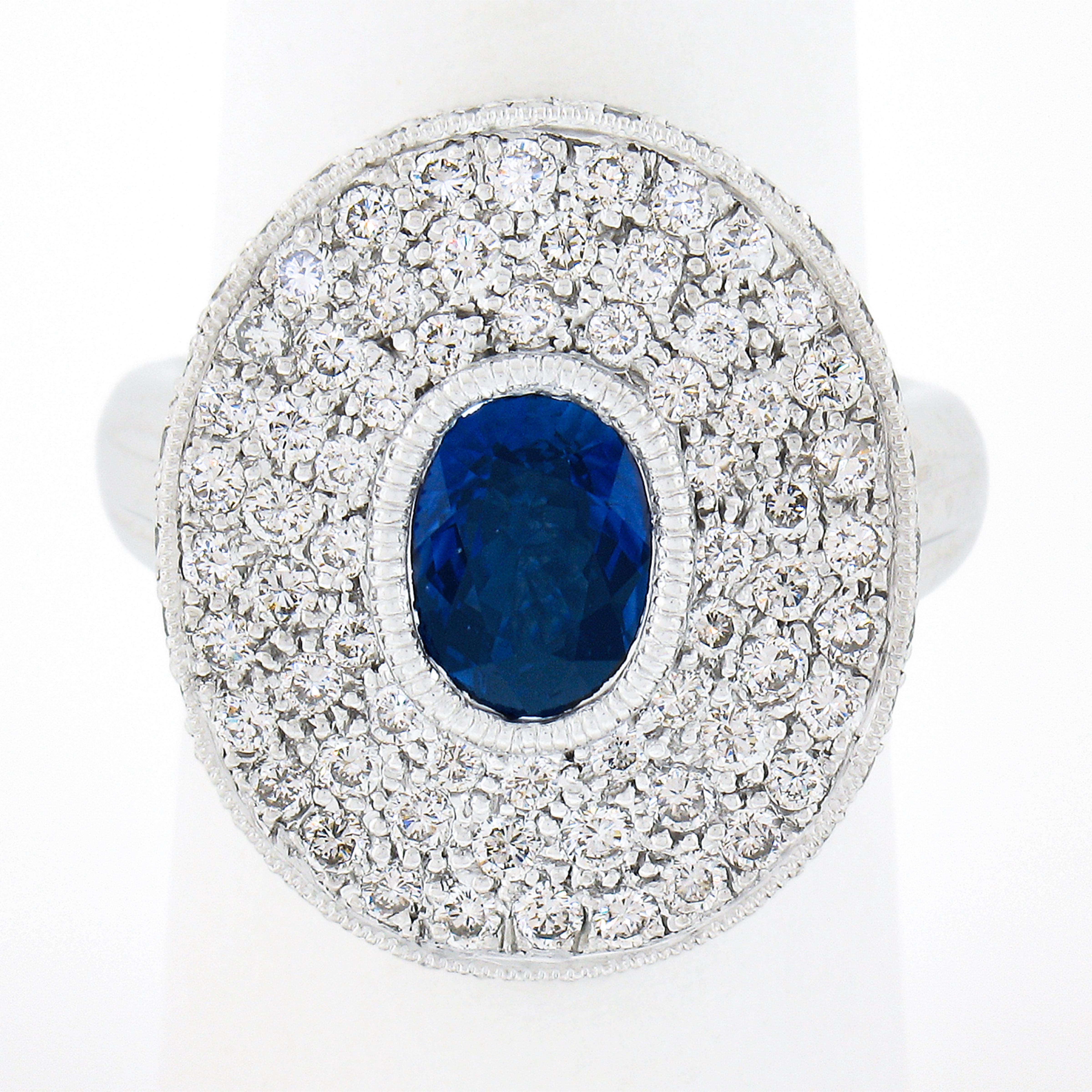 This magnificent and very well made cocktail ring is crafted in solid platinum, and features a large oval platter design that is completely covered with incredible pave work and set with the finest quality sapphire and diamonds throughout. The