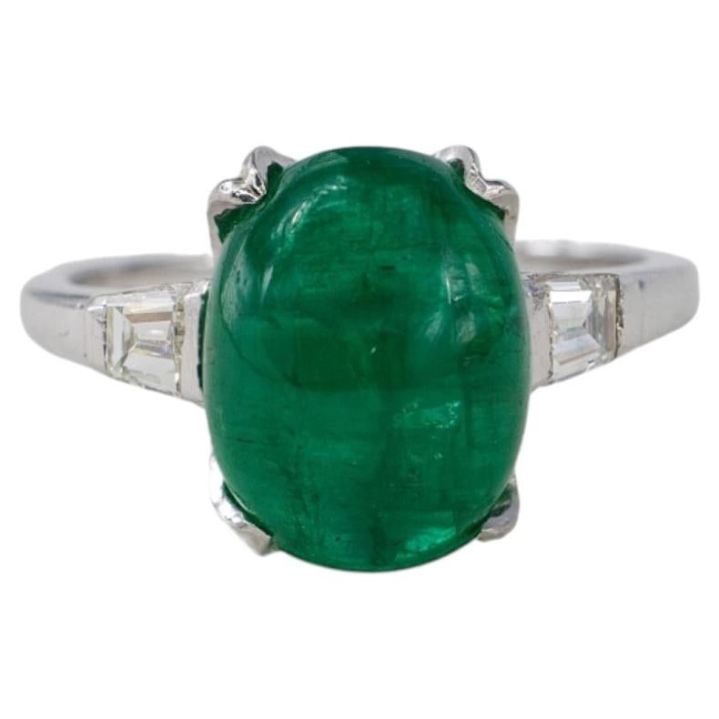 Platinum Oval Cabochon Emerald and Tapered Baguette Diamond Three-Stone Ring