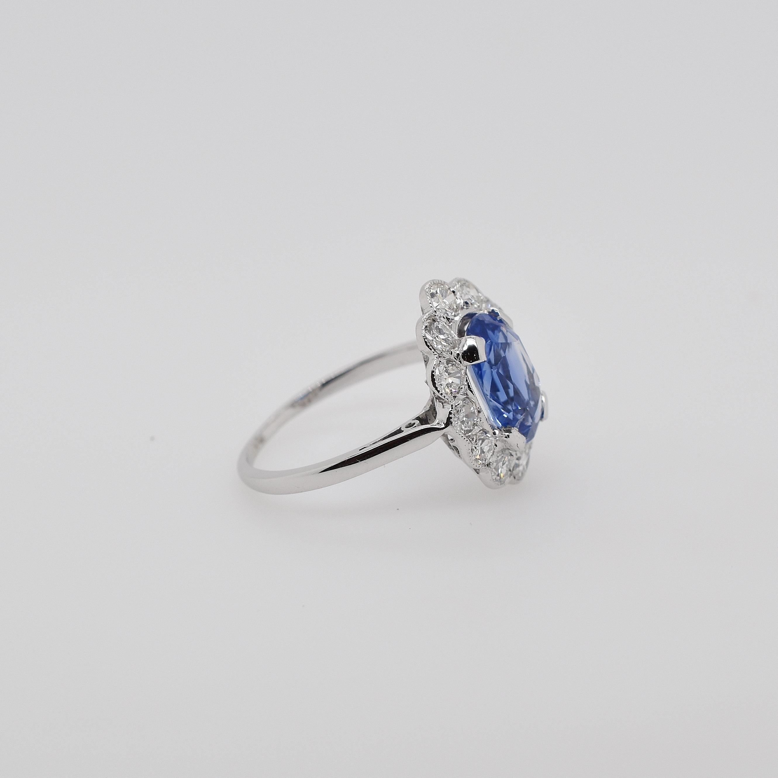 Platinum Ceylon sapphire and semi modern cut diamond scalloped cluster ring. The centre oval Ceylon sapphire is 2.50ct. Then there are 12 semi modern diamonds totalling 1.10ct in the grounding cluster. This beautiful Art Deco piece has been recently
