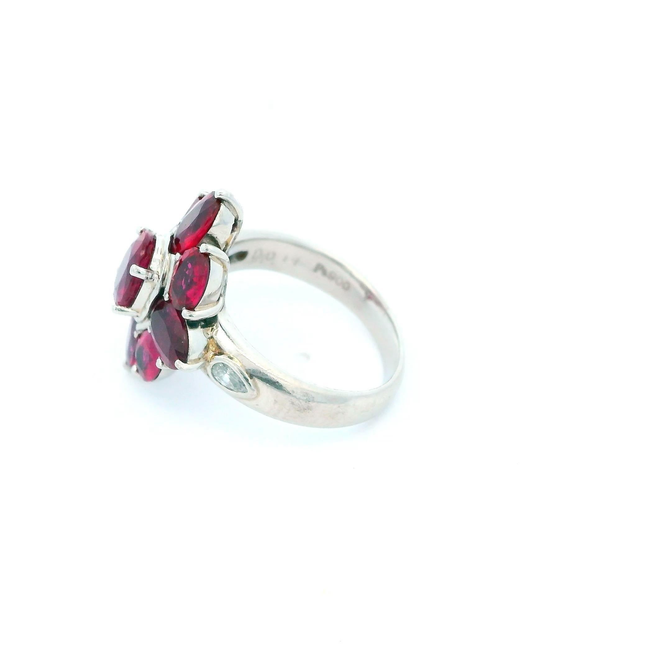 A symphony of elegance and vibrant color.

This striking ring showcases a stunning 4.93 carat oval-cut ruby, radiating a rich red hue. The central gem is surrounded by a cluster of equally vibrant rubies, all set in a sleek platinum band.

A bold