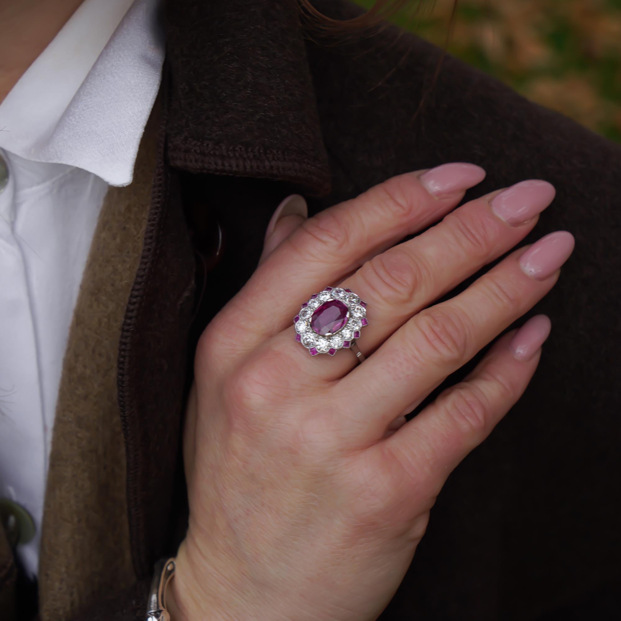 Platinum oval-shaped natural Burma ruby cluster ring surrounded by an old-cut and round brilliant-cut diamonds. 
X - Ray been tested positive for  platinum purity. 

Dimensions - 
Finger Size (UK) = N 1/2 (EU) = 55.5 (US) = 7.25
Weight: 5.00