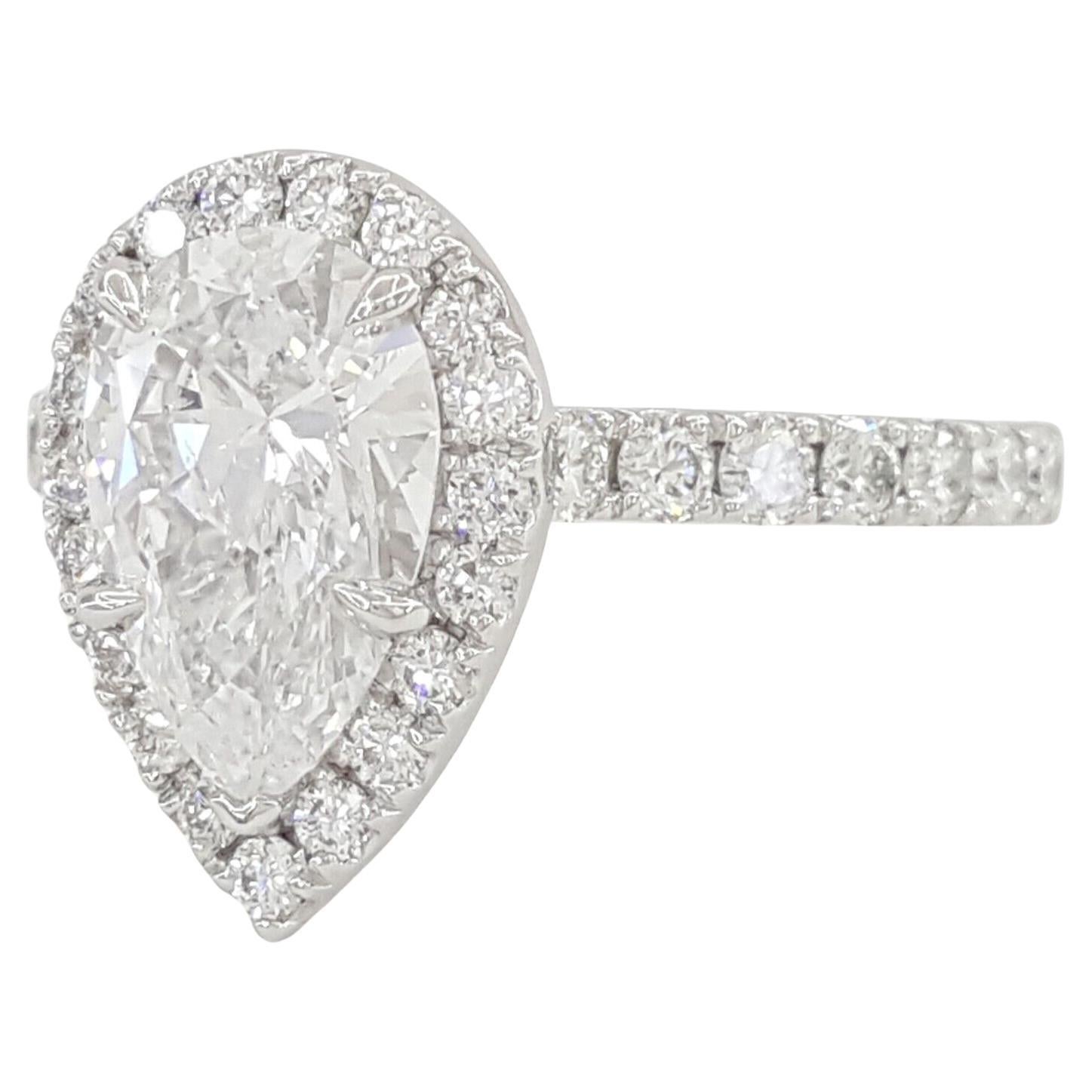 Platinum encases a Pear Brilliant Cut Diamond Halo Engagement Ring with a total weight of 2.43 carats. The ring itself has a weight of 6.3 grams and is sized at 6.25. Its centerpiece is a natural 1.71-carat Pear Brilliant Cut Diamond, boasting D