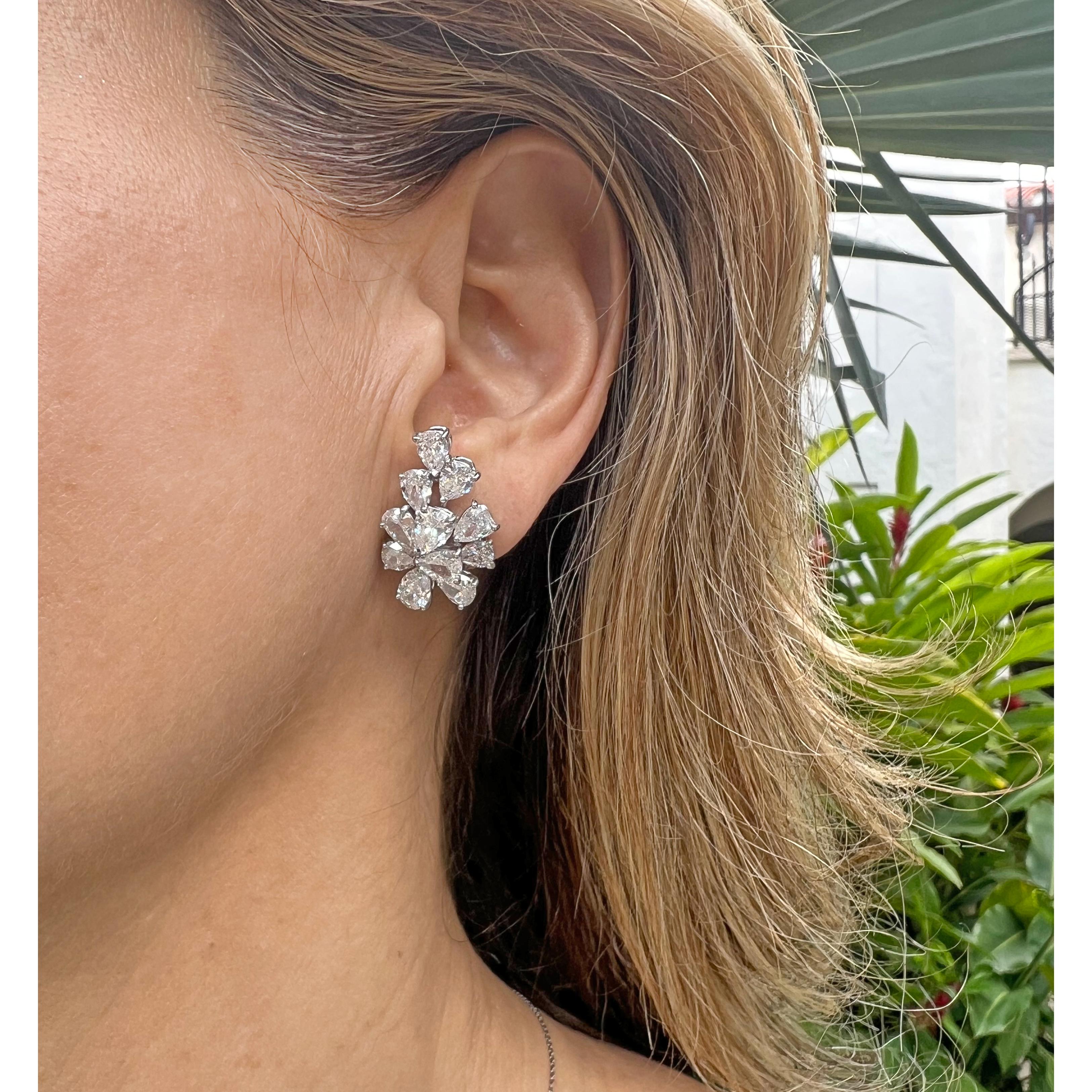 Diamond cluster earclips, each featuring eleven near-colorless pear brilliant-cut diamonds prong-set in platinum. Twenty-two diamonds weighing approximately 9.72 total carats (H-J color, SI1-I1 clarity). 18k white gold omega-style clip backs (posts