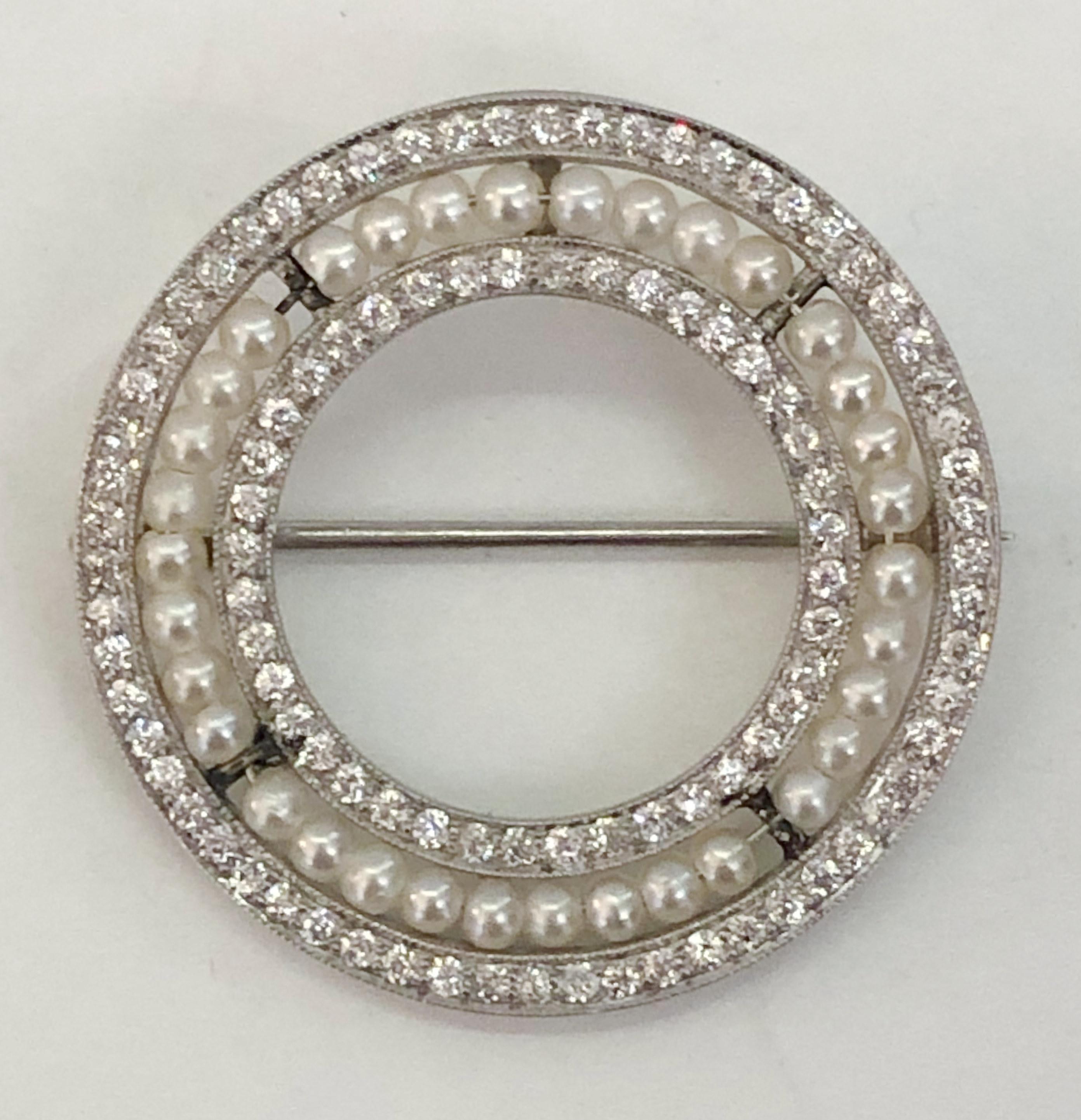 Broche vintage ronde en platine, avec environ 1 carat de diamants alternant avec des perles, Italie 1910-1920s 
Diamètre 3,2 cm