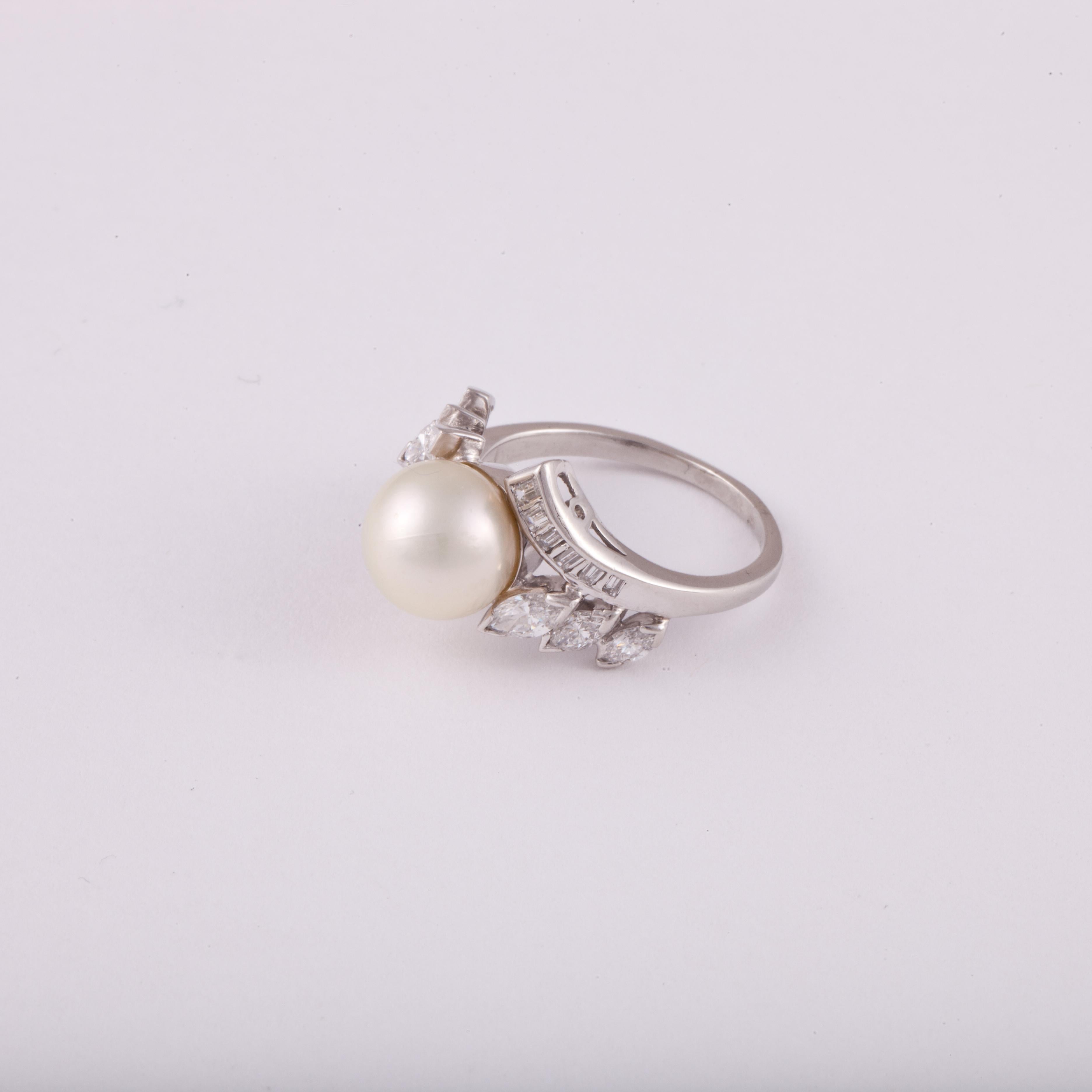 Platinum ring featuring a cultured pearl in the center with marquise and baguette diamonds.  The pearl measures 9.25mm.  The diamonds total 1.05 carats; F-G color and VS clarity.  Presentation area is 3/4 inches by 1/2 inch and stands 3/8 inches off