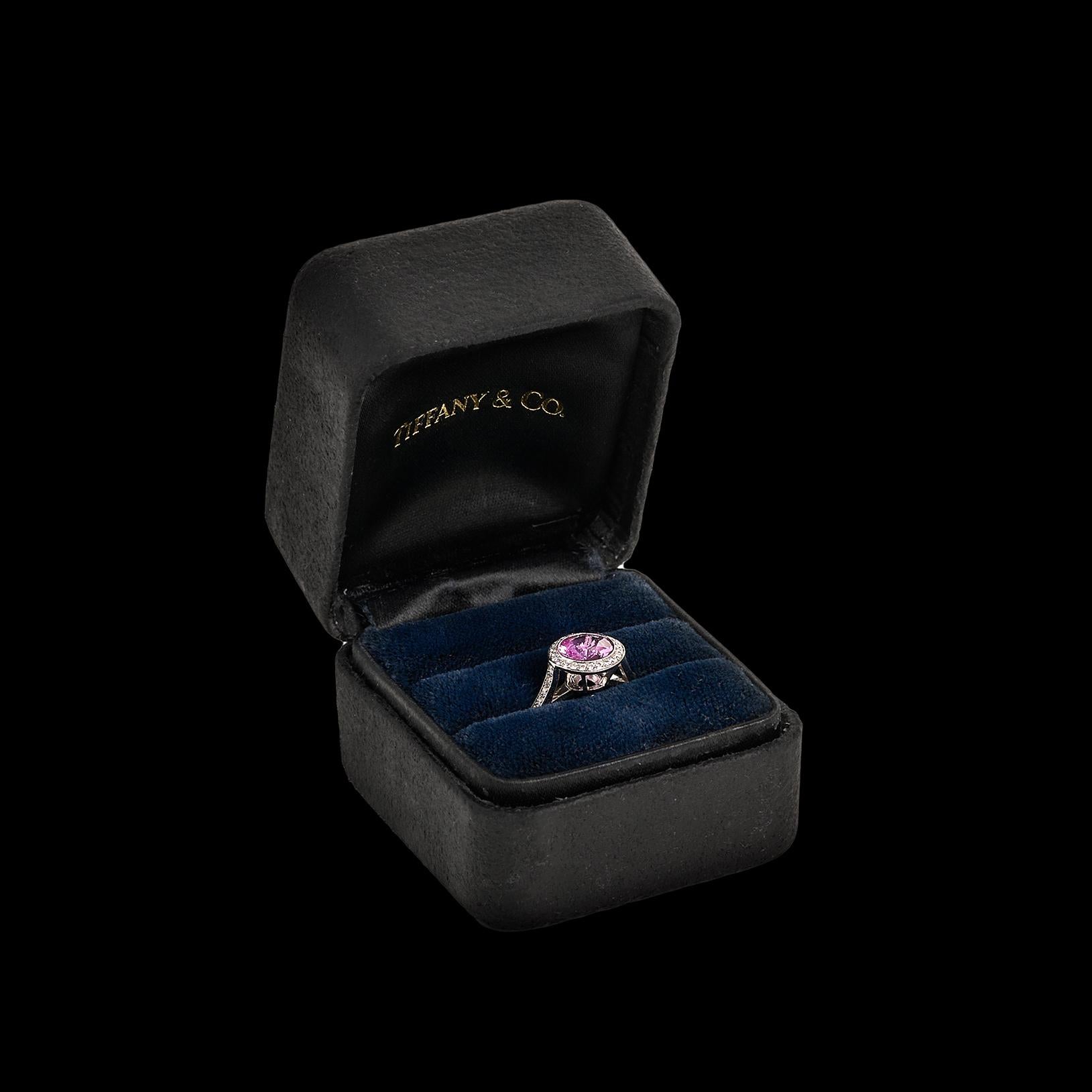 If you're looking for the perfect colored stone ring, you may have just found it in this stunner from the one and only Tiffany & Co. Featuring a natural round pink sapphire weighing 1.12 carats at it's center, the exceptional pink stone is