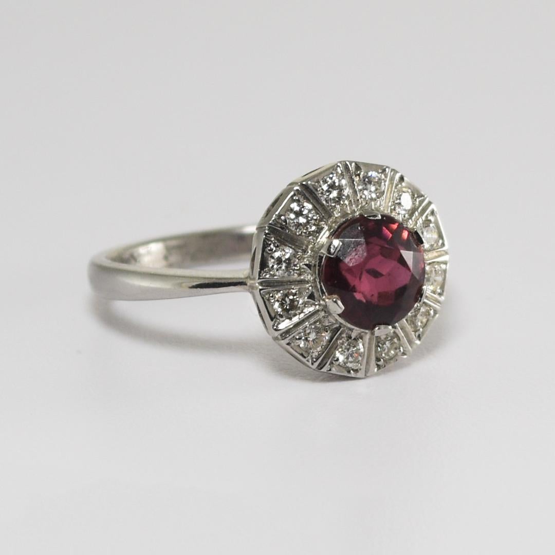 This is a beautiful, Pinkish-Red Rubellite Tourmaline with a diamond halo accent Ring
Overall, it weighs 4.70 grams.
It contains a 6.5mm round rubellite Pink Tourmaline mounted in the center, with a carat weight of 1.0.
The ring is accented by