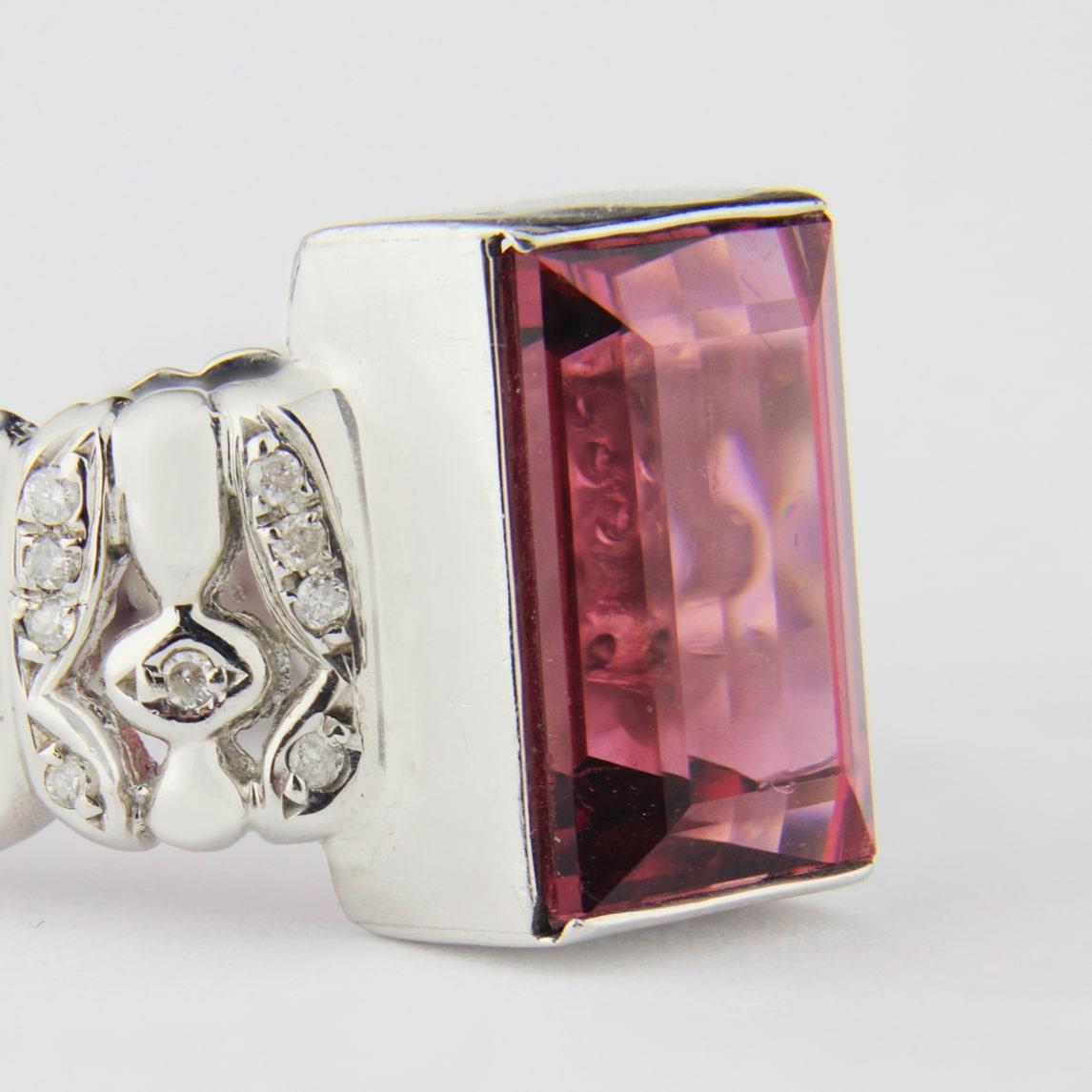 A chic platinum ring with a central pink tourmaline that has shoulders set with diamonds. The central pink tourmaline is 6.95 carat 'bright mid pink eye clean' which has been end cap set. The shoulders of the piece are patterned and set with 28