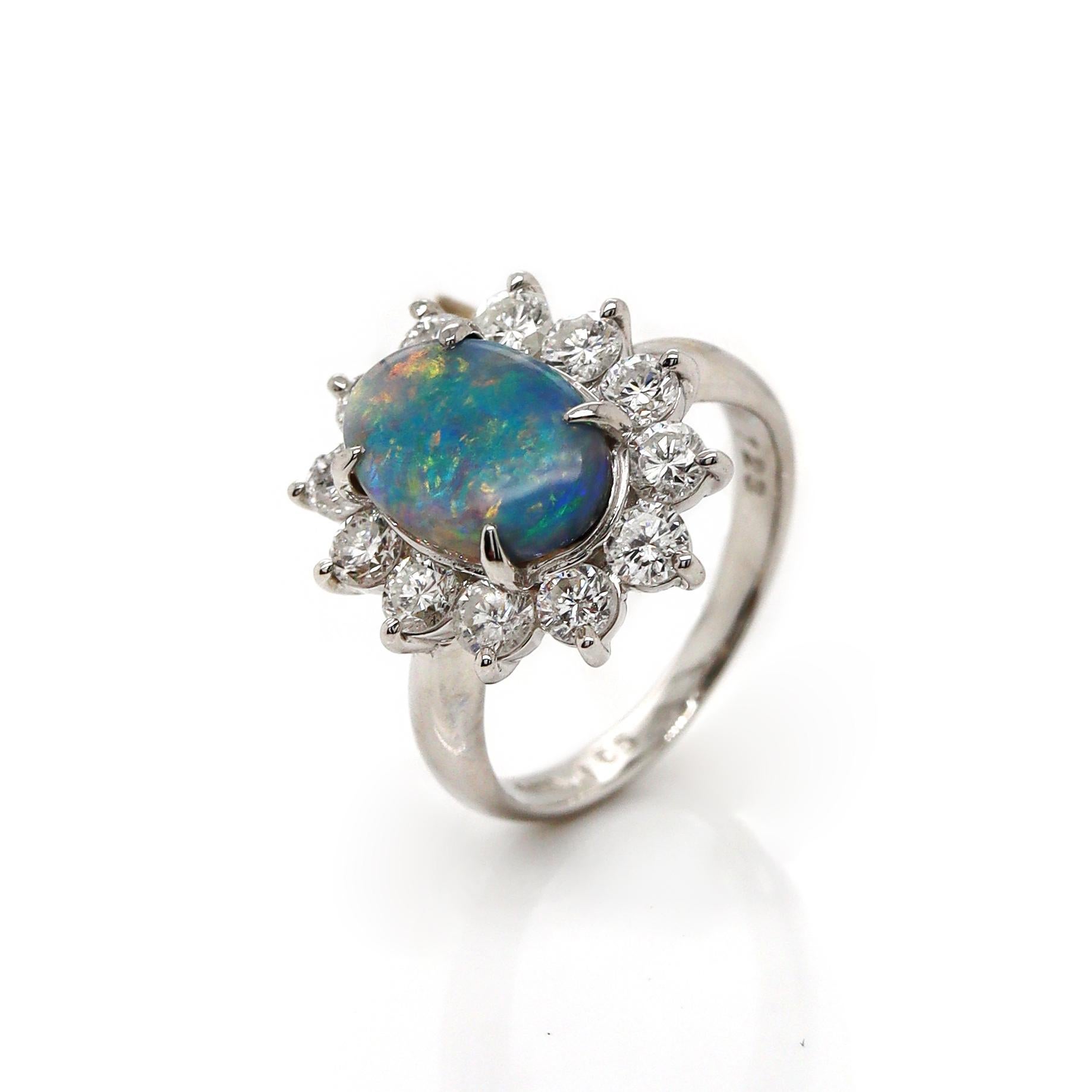Platinum PT900 Australian Opal & Diamond Ring

This stunning platinum ring showcases an Australian opal at its center, an oval-cut gem that radiates an array of vibrant colors, from deep blues and greens to flashes of fiery orange and red. The opal