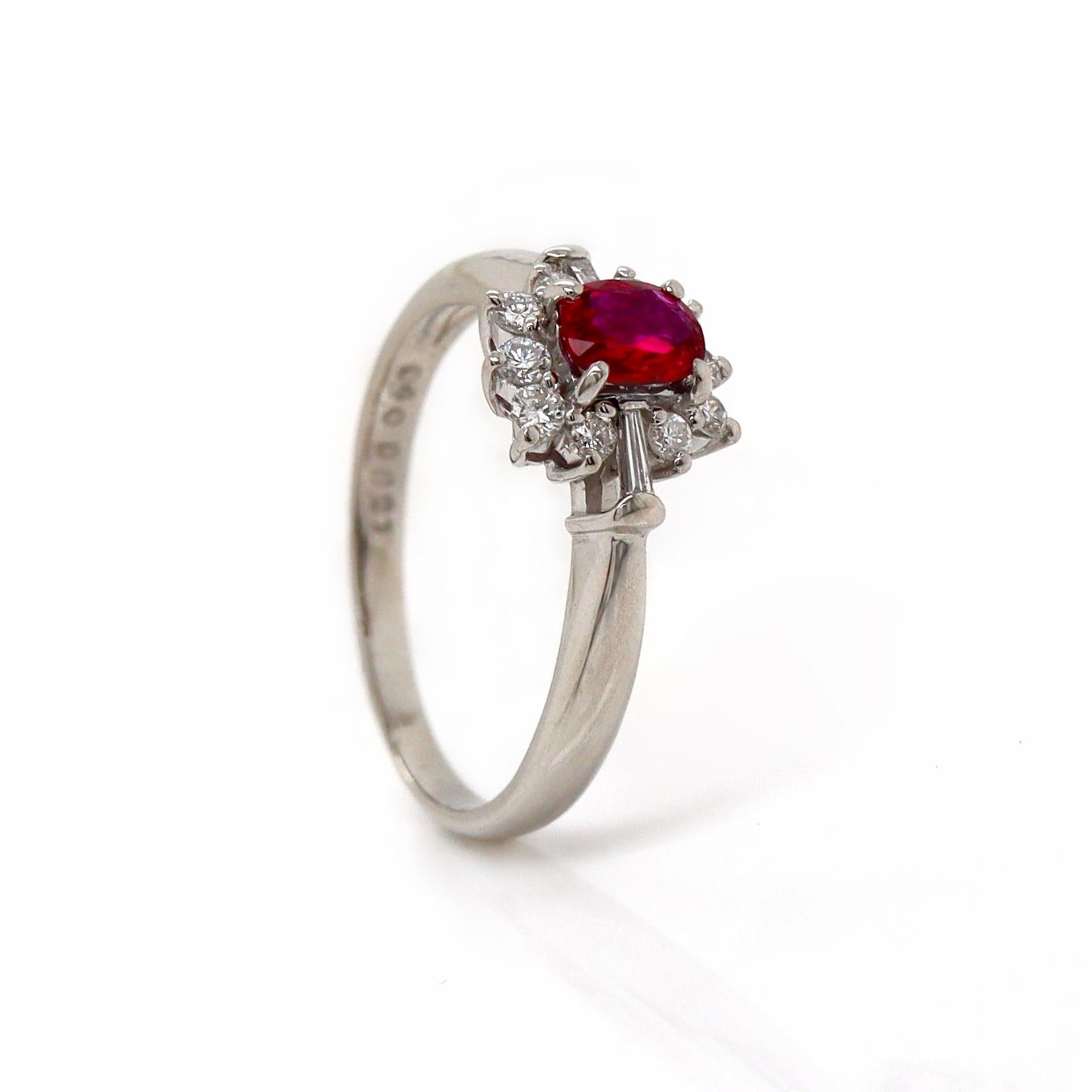 Platinum PT900 Ruby & Diamond Ring

This elegant platinum ring features a striking blood-red ruby, oval-cut and set at the center, exuding a deep, rich hue that commands attention. Surrounding the ruby is a halo of sparkling round brilliant and