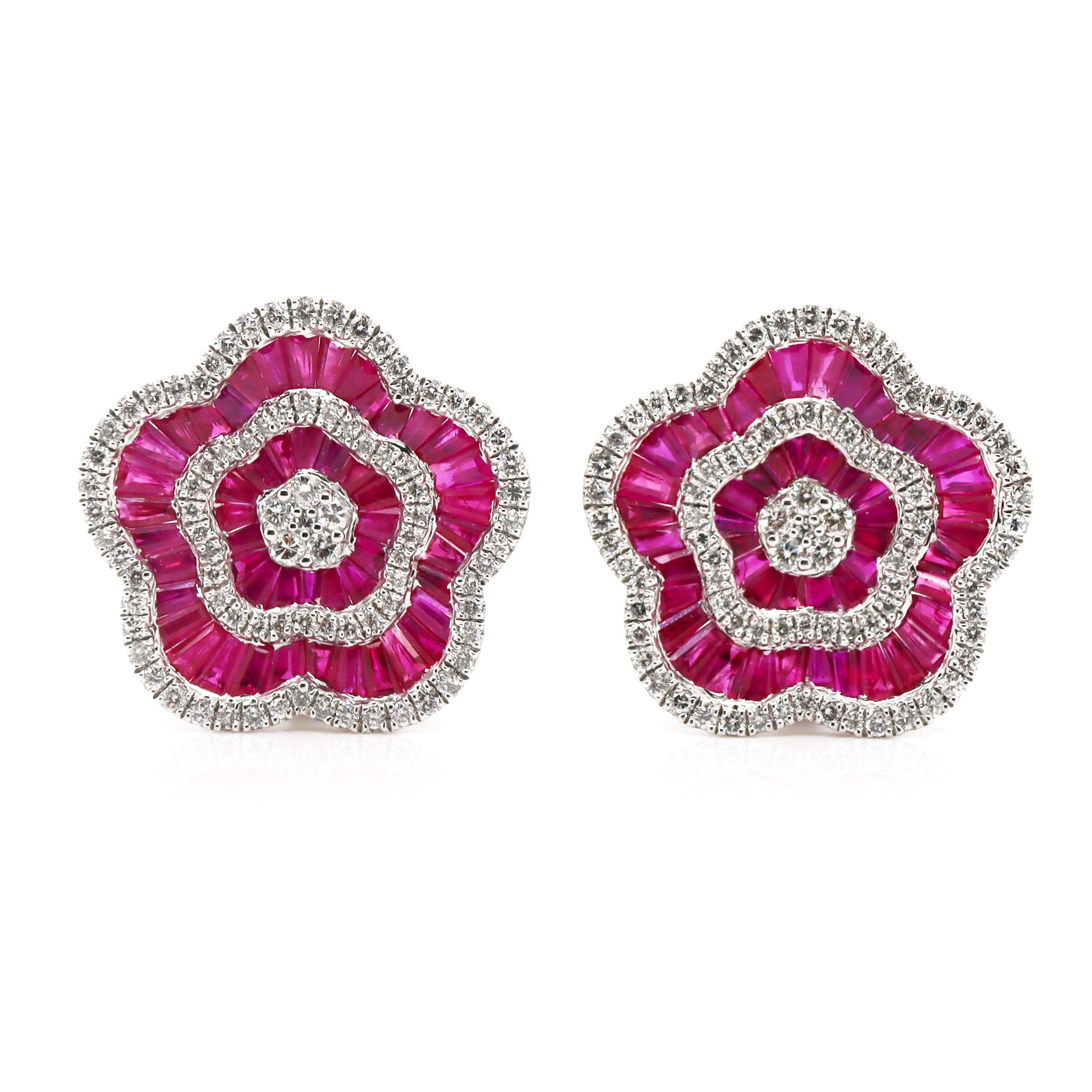 Platinum PT900 Ruby & Diamond Earrings

These platinum earrings make a bold statement with their stunning floral design, featuring vivid red French carré-cut rubies at the center of each blossom. Surrounding the rubies are brilliant round diamonds,