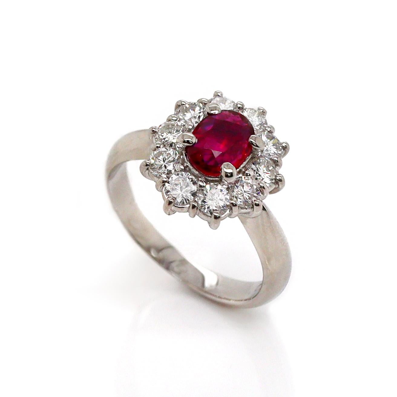 Platinum PT900 Ruby & Diamond Ring

This elegant platinum ring features a striking blood-red ruby, oval-cut and set at the center, exuding a deep, rich hue that commands attention. Surrounding the ruby is a halo of sparkling round brilliant-cut