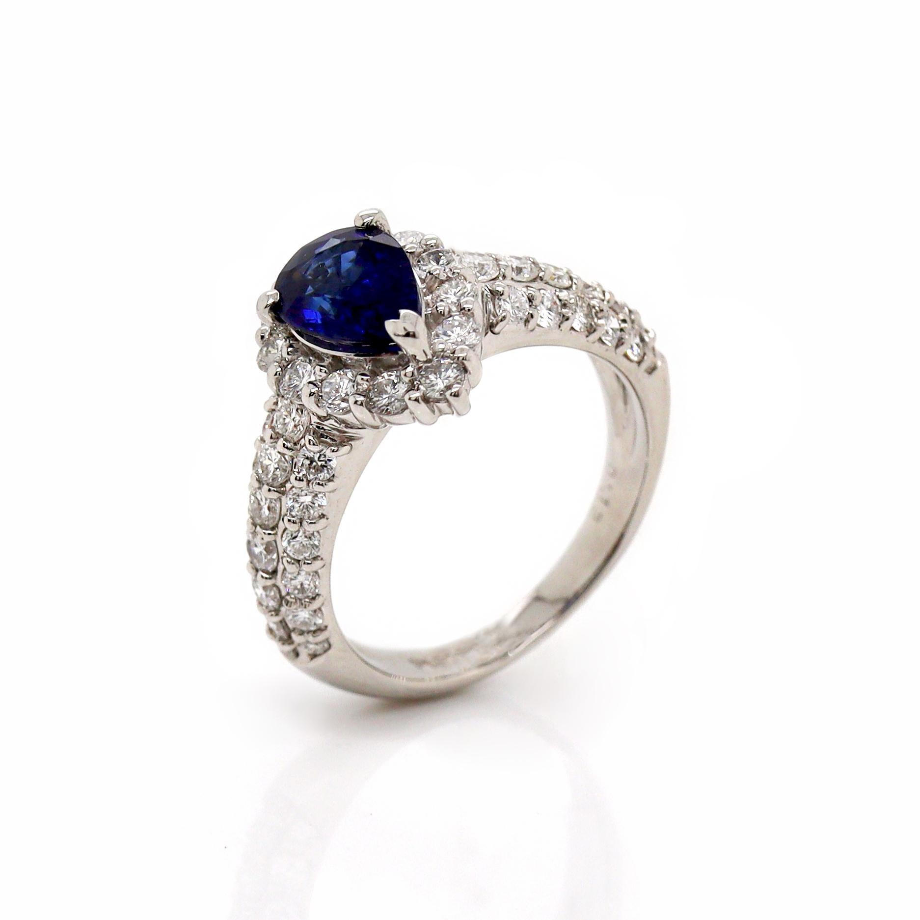 Platinum Pt900 Sapphire and Diamond Ring

This exquisite platinum ring features a 1.17ct pear-shaped blue sapphire at its center, showcasing its rich, deep blue color that radiates with an inner glow. Surrounding the sapphire is a halo of round