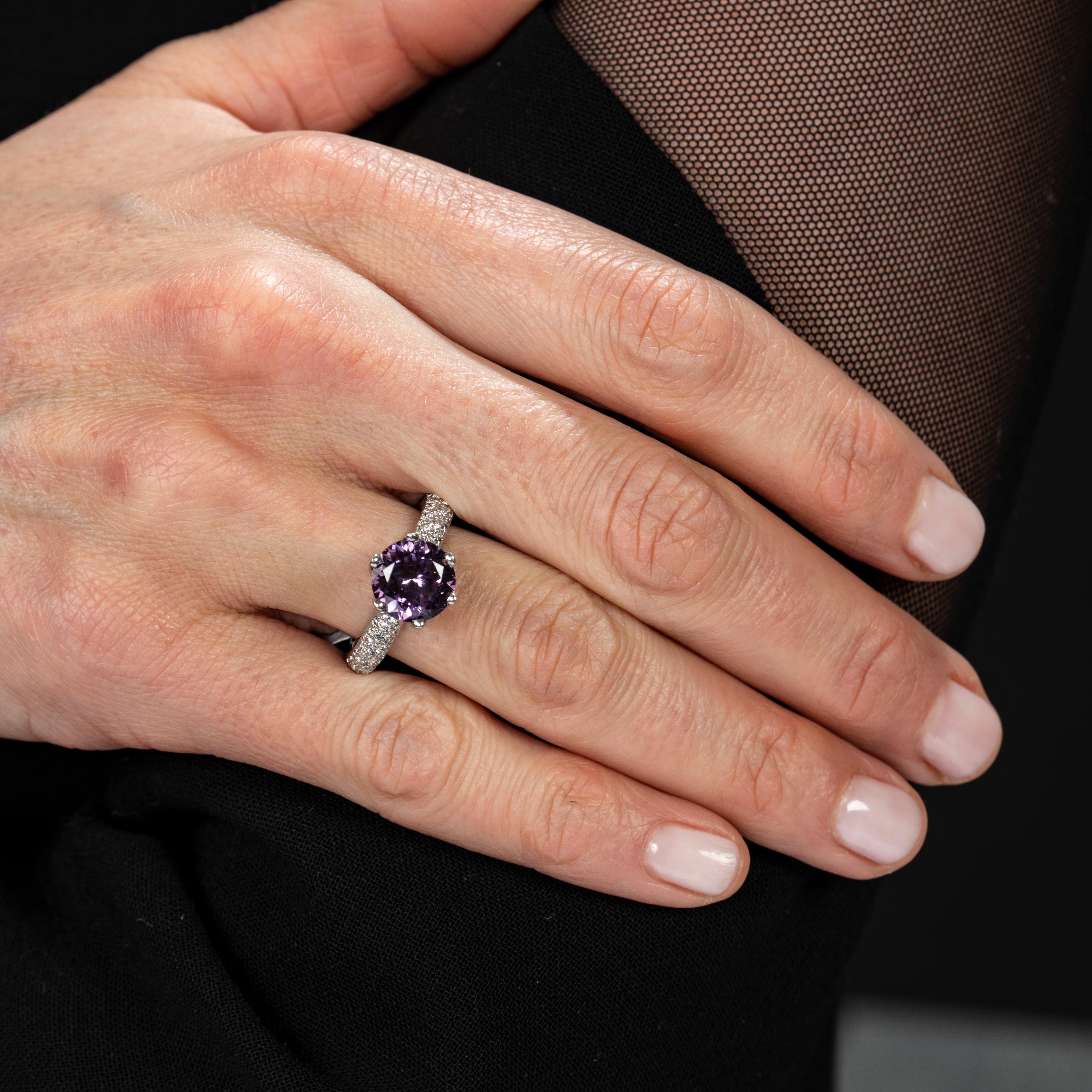 This ring is a timeless classic. The attractive six-prong set purple spinel, set atop a cascade of shimmering diamonds set in platinum band, is a piece that you will cherish everyday hereafter. An heirloom worthy accompaniment to any style of dress