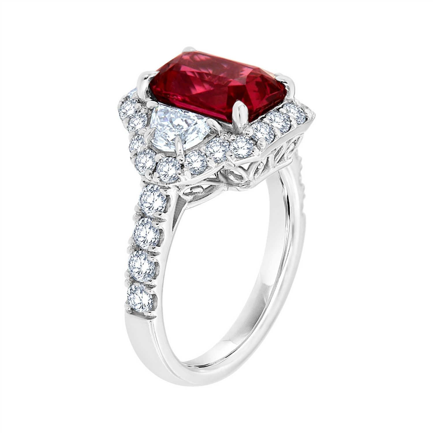 This platinum ring features a One-of-A-Kind Natural Red Ruby Octagonal Shape flanked by two Trapezoids Shaped diamonds and circled by a halo of brilliant round diamonds. A row of four (4) diamonds micro-prong set along 2.7 mm band. This Red-Carpet