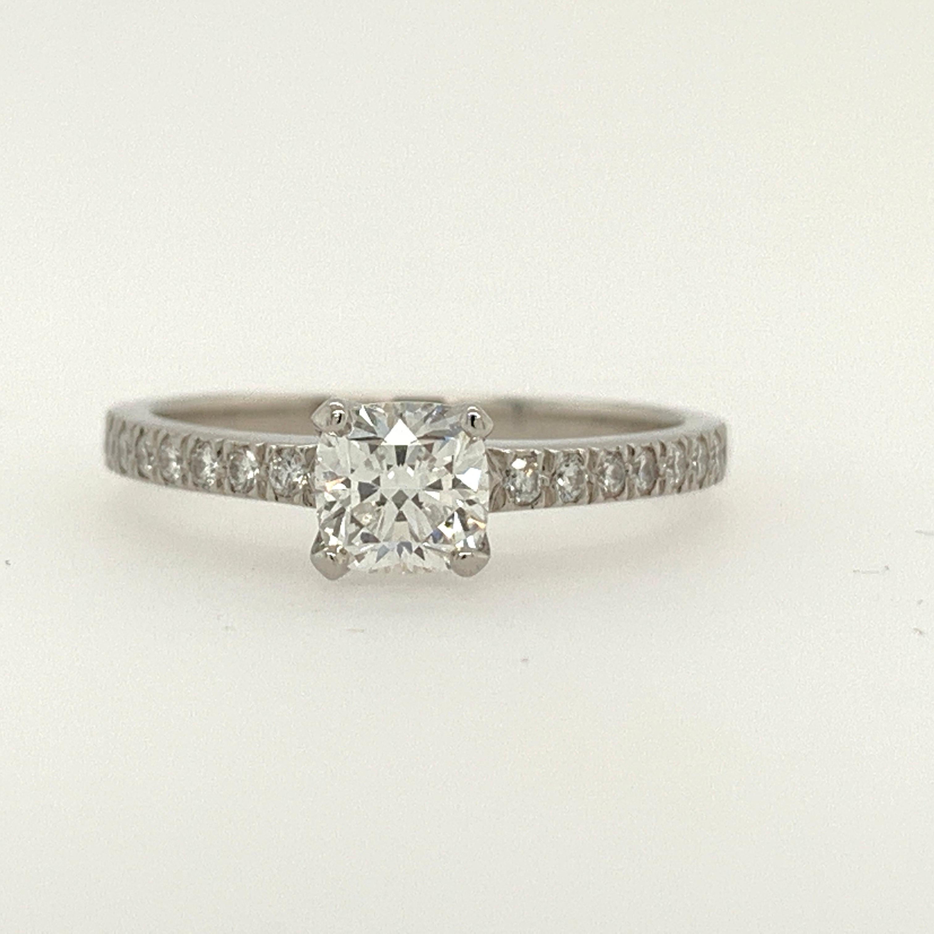 Platinum ring (size 6.75) set with 0.16 carats of colorless rounds and a 0.59ct, F color, Internally Flawless center Cushion. Original paperwork is included. 