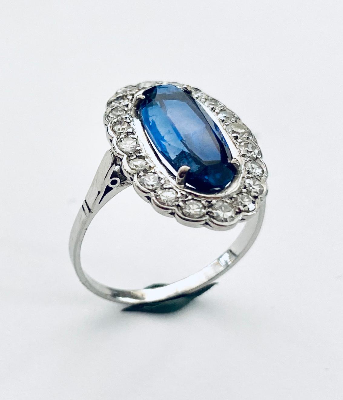 - One (1) 950 / - Platinum ring, model oval entourage
- Set with 20 8 side cut diamonds weighing: 0.66 ct
- 1 oval cut synthetic sapphire of 3.30 ct.
- France / England ca 1930
- Weight: 4.63 grams size: 18+ (57.5 )

Synthetic stones in