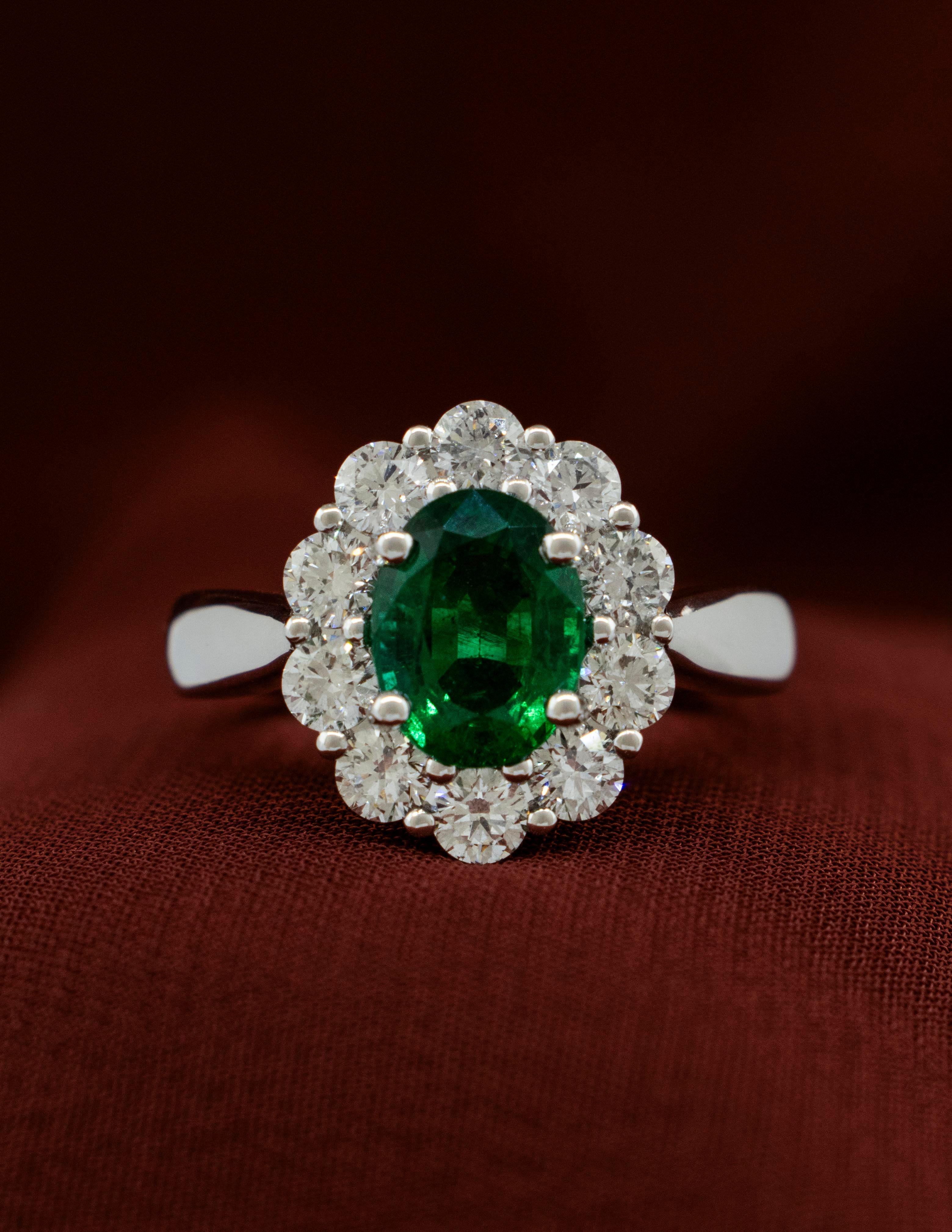 A Ladies Emerald and Diamond ring mounted in a Platinum setting. This is a high-quality ring made with the finest elements. The Colombian Emerald is a vibrant deep green oval cut weighing approximately 1.56 carats. It is an exceptional stone with