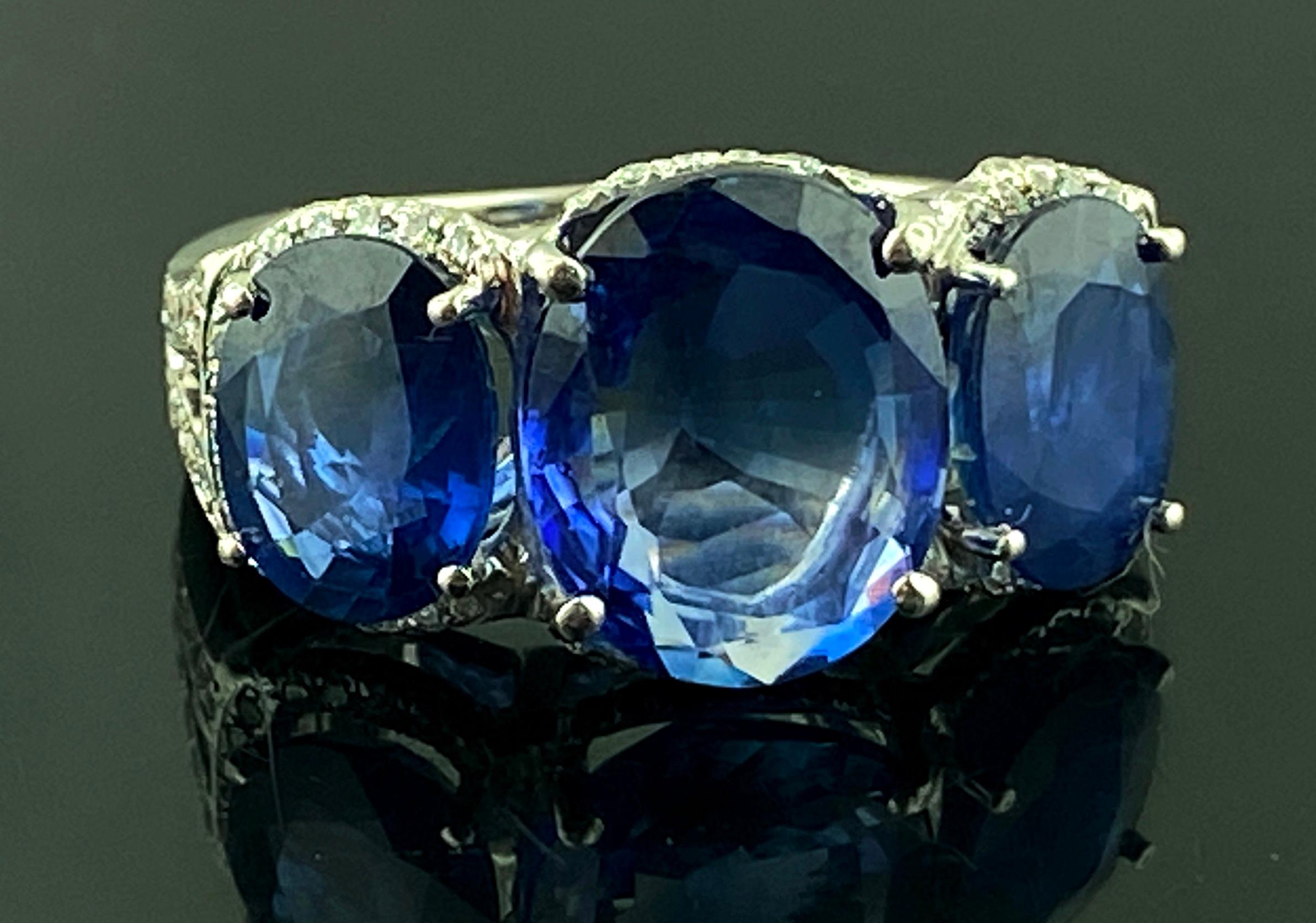 Set in Platinum, weighing 12 grams, are three Oval Cut Blue Sapphires.  The Center Sapphire is 5.48 carats with two side Sapphires weighing 2.41 carats and 2.06 carats for a total Sapphire weight of 9.95 carats.  The mounting includes 103 Round