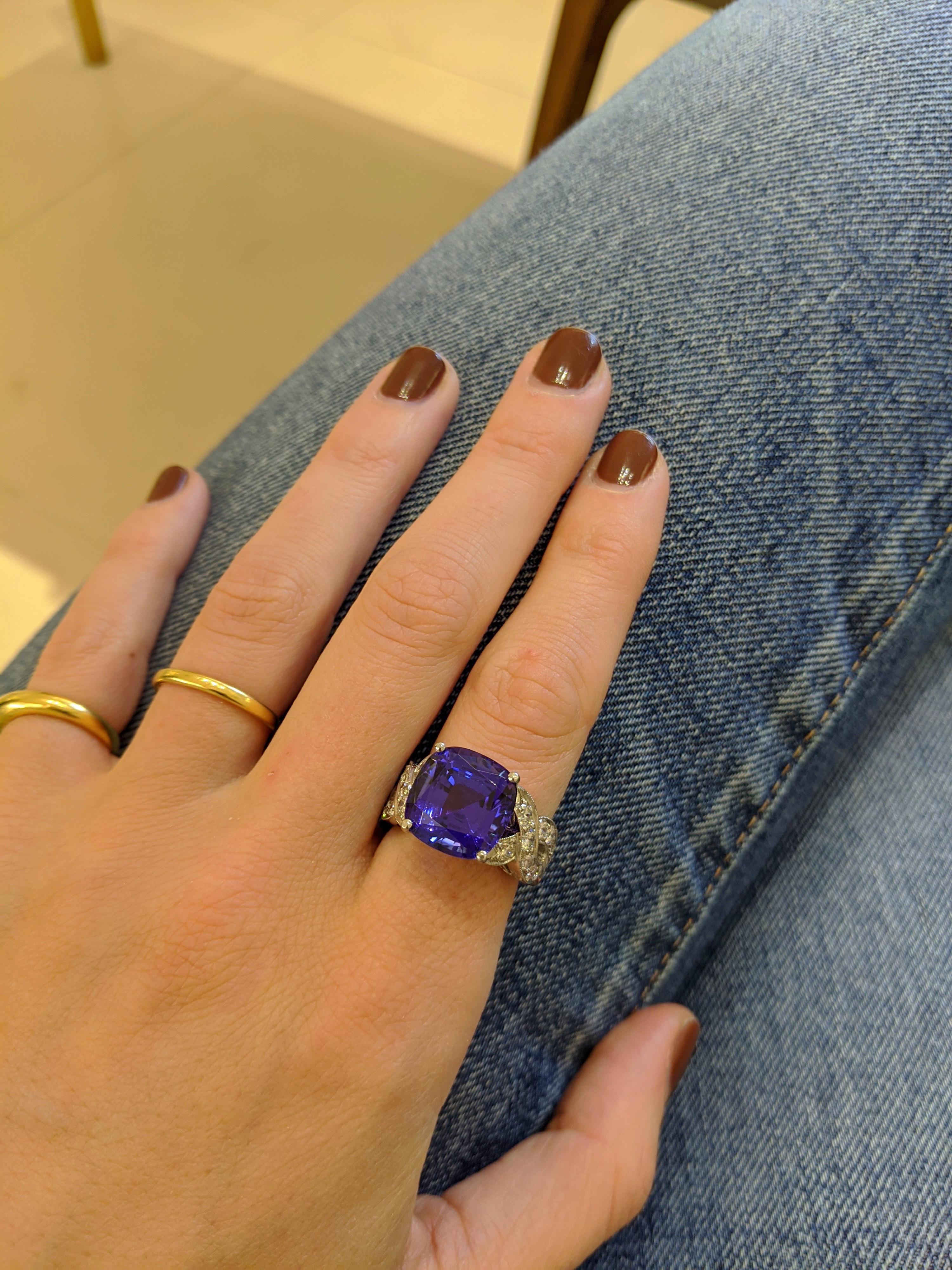 Questo pezzo unico, creato da Cellini Jewelers NYC, presenta una montatura in platino fatta a mano che circonda un'intensa tanzanite con taglio a cuscino. Questa pietra molto vibrante è incastonata in una montatura a quattro punte con intrecci di