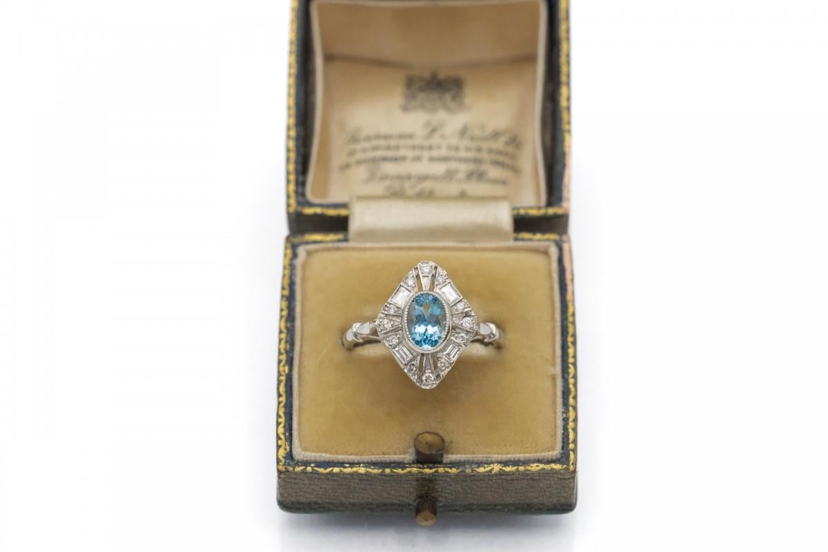 A platinum ring with a sophisticated form, with a central oval faceted aquamarine weighing 0.80 ct.

The ring is decorated with 12 brilliant-cut diamonds weighing 0.12ct and 4 rectangular faceted diamonds weighing 0.20ct.

Made of 950
