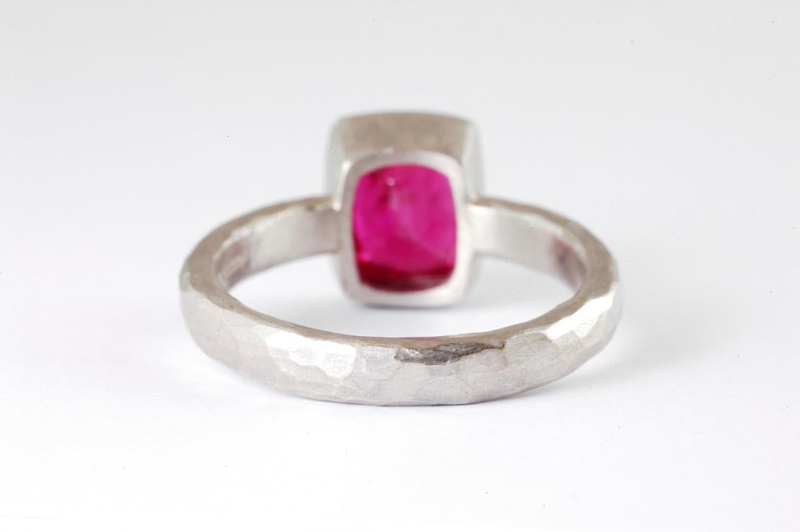 Platinum ring with cushion shaped ruby and channel set brilliant cut diamonds handmade in Notting Hill London by renowned British jewellery designer Malcolm Betts. A 3mm platinum band with channel set brilliant cut diamonds flanking a beautiful
