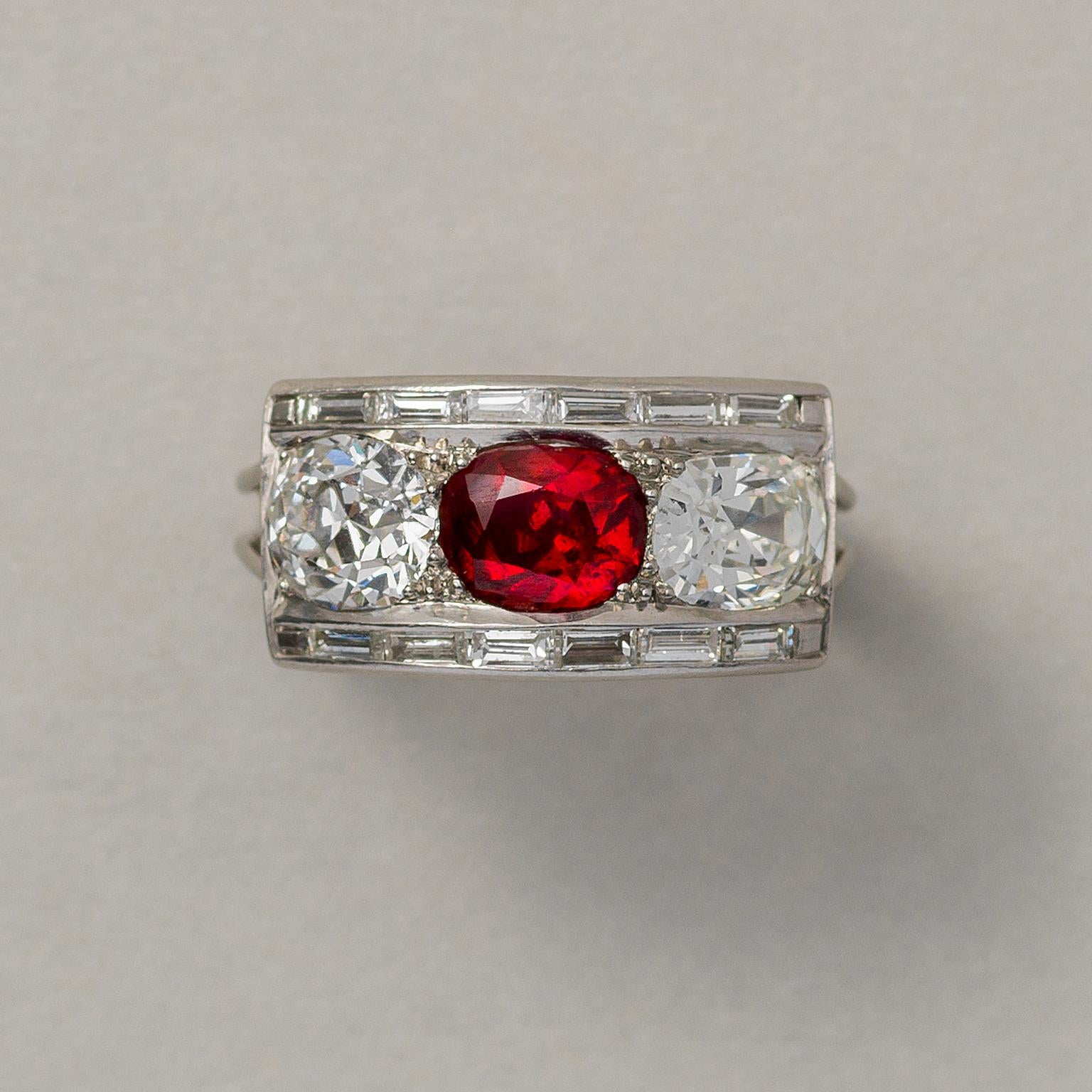 A platinum Art Deco ring, set with a faceted oval unheated natural Burma ruby (app. 2.5 carat 6.2 x 5.0 x 4.2 mm, circa 1.55 carat) and two old-cut diamonds (each app. 1.00 carat in total), framed by two rows of six baquette cut diamonds (app. 0.24