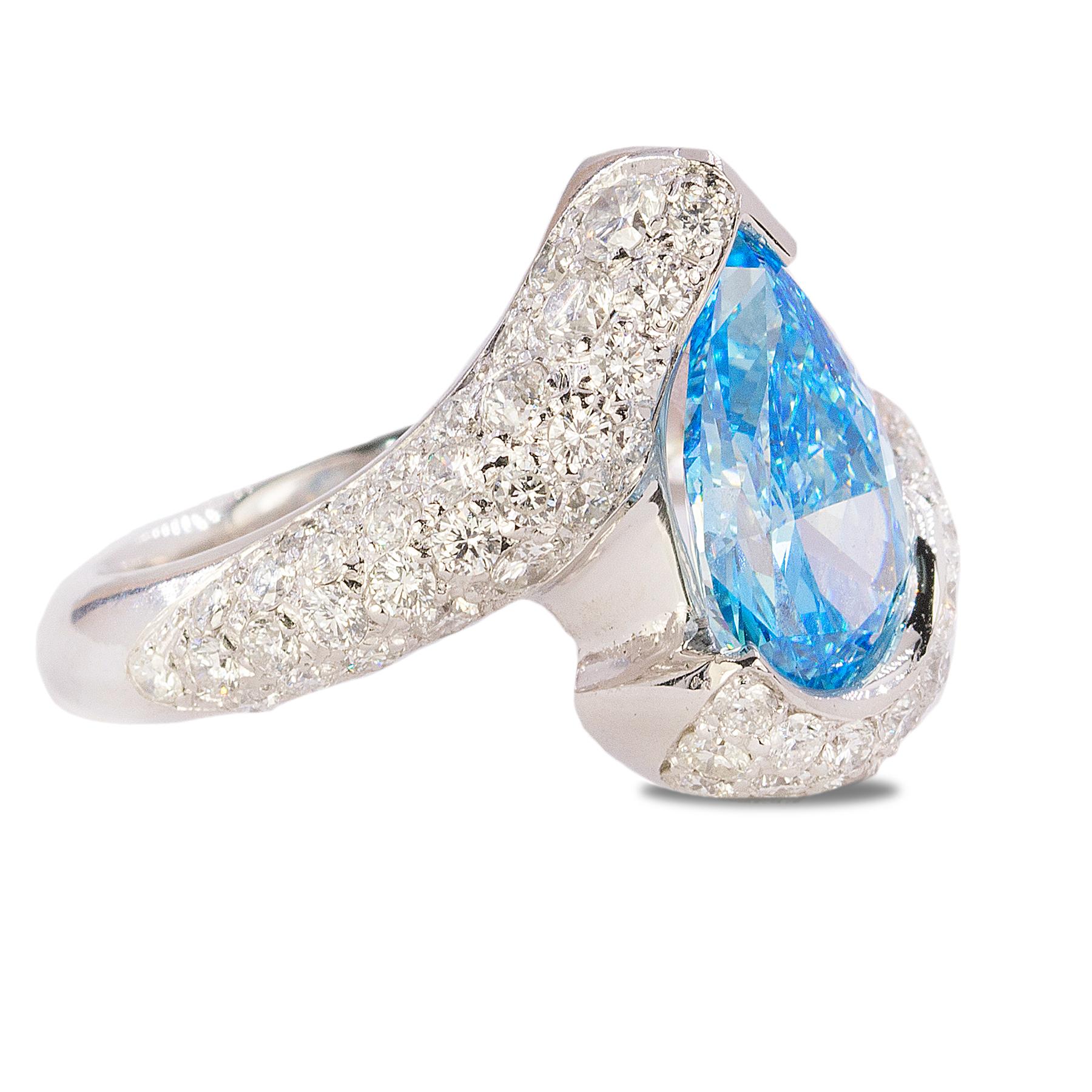 Platiunm Ring with GIA certified HPHT Fancy Vivid Blue, VVS2 Pear Shape DIamond and 2.71 carats of pave set modern round brilliant diamonds. 