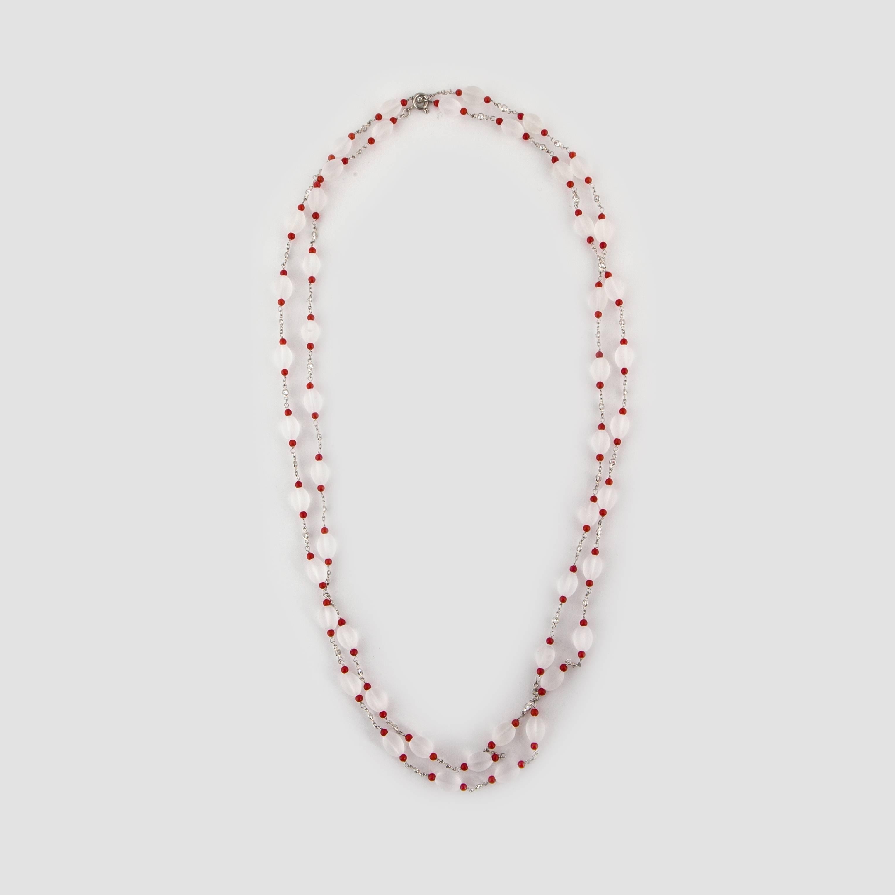 Necklace composed of platinum featuring oval carved frosted rock crystal beads accented by round coral beads on each side.  In addition there are 48 round diamonds that total 1.25 carats; H-I color and VS2-SI1 clarity.  Necklace measures 46 inches