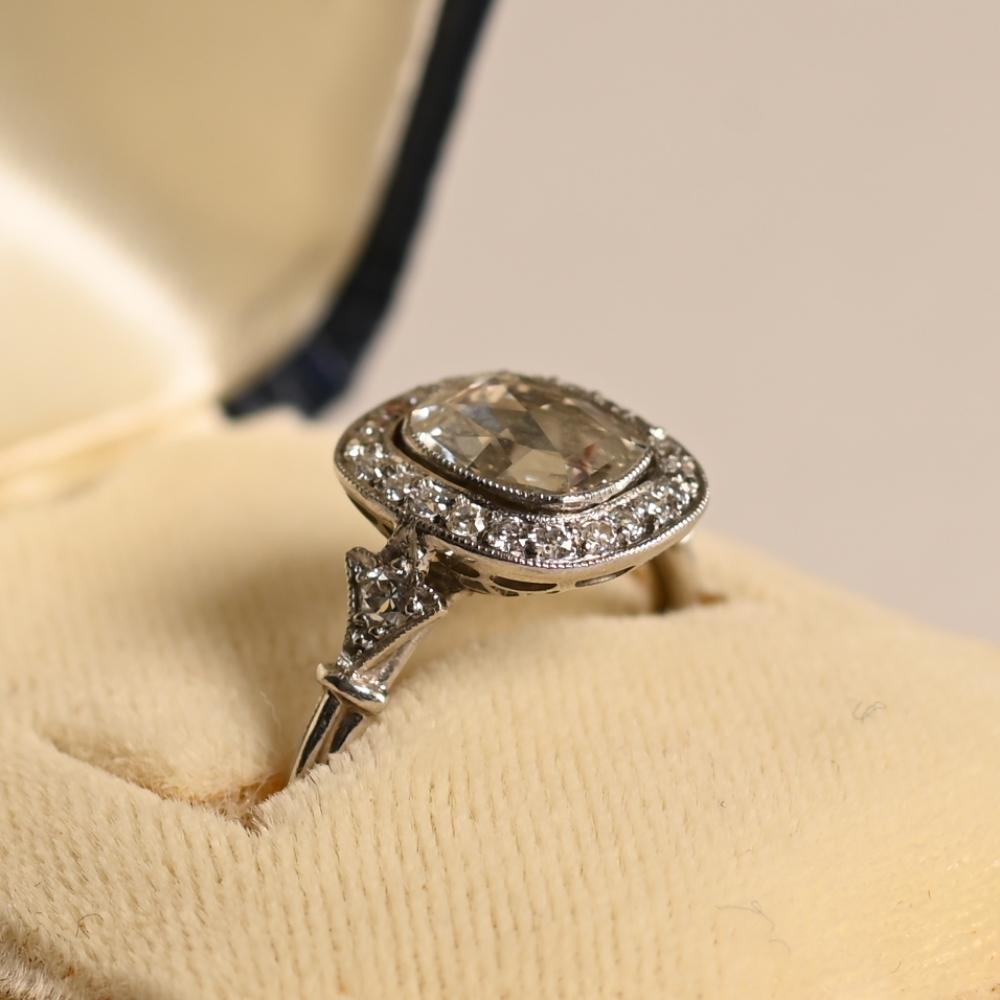 Dieser exquisite Diamant-Verlobungsring pr�äsentiert einen fesselnden ca. 1,00-Karat-Diamanten im Rosenschliff, der vom GIA mit dem Farbgrad H und der Reinheit VS1 zertifiziert wurde. Der Mittelstein ist elegant in eine Lünette gefasst und wird von
