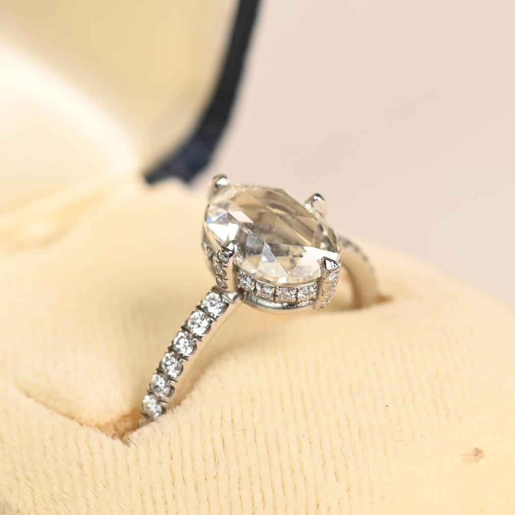 Questo squisito anello di fidanzamento presenta un diamante ovale con taglio a rosa di circa 1,5 carati, di colore I e purezza VS1. Il caratteristico taglio a rosa offre un fascino romantico e senza tempo, enfatizzando la naturale brillantezza del